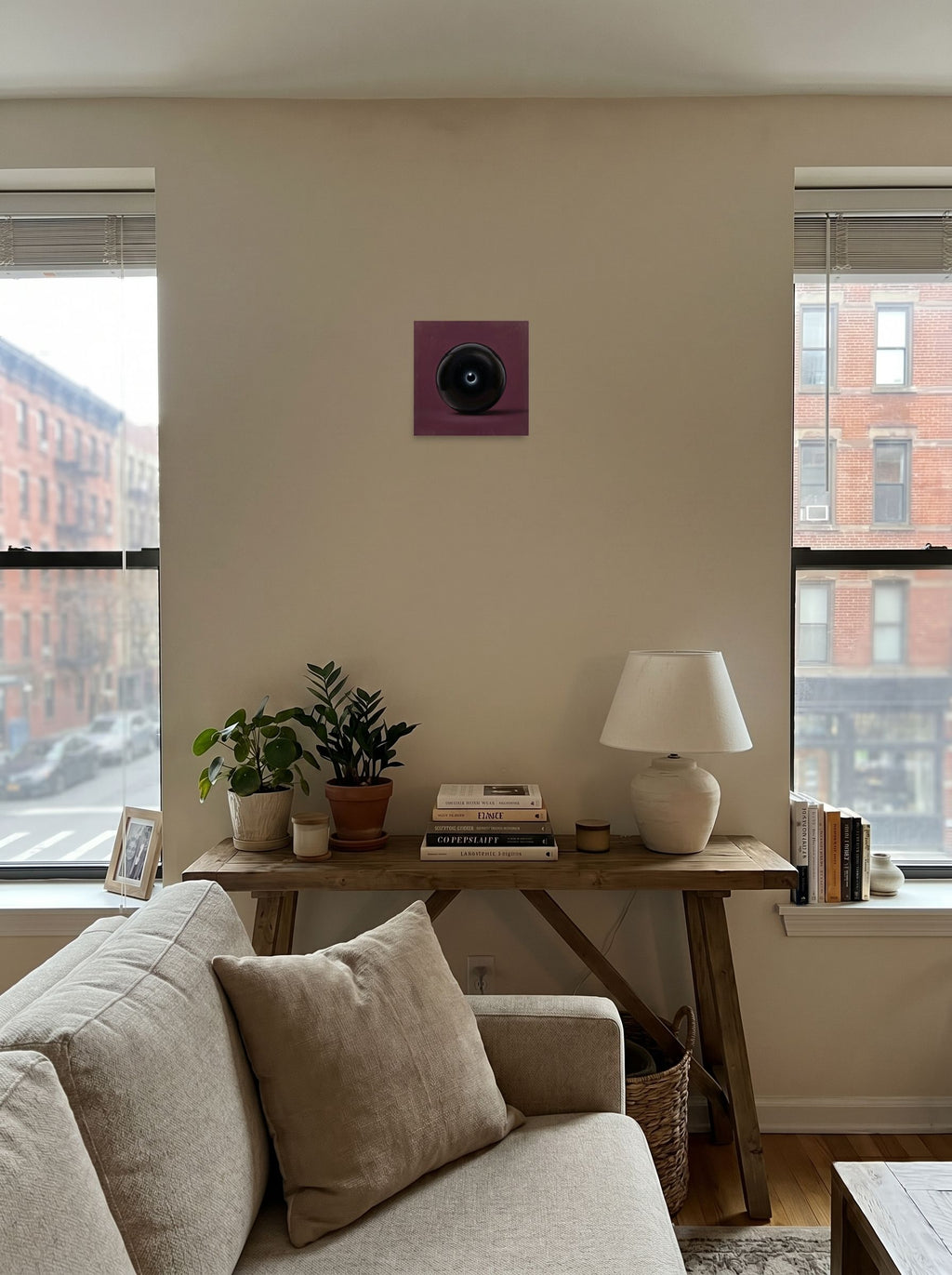 A 10x10 inch unframed paper Surrealism print of 'Obsidian Eye' displayed in the center of a living room.