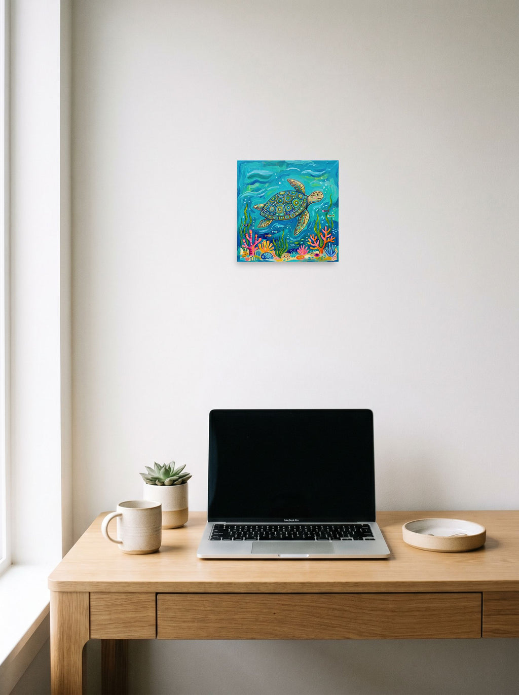 A 10x10 inch unframed paper Naive art print of 'The Painted Sea Turtle' hanging above a worktable with a laptop.