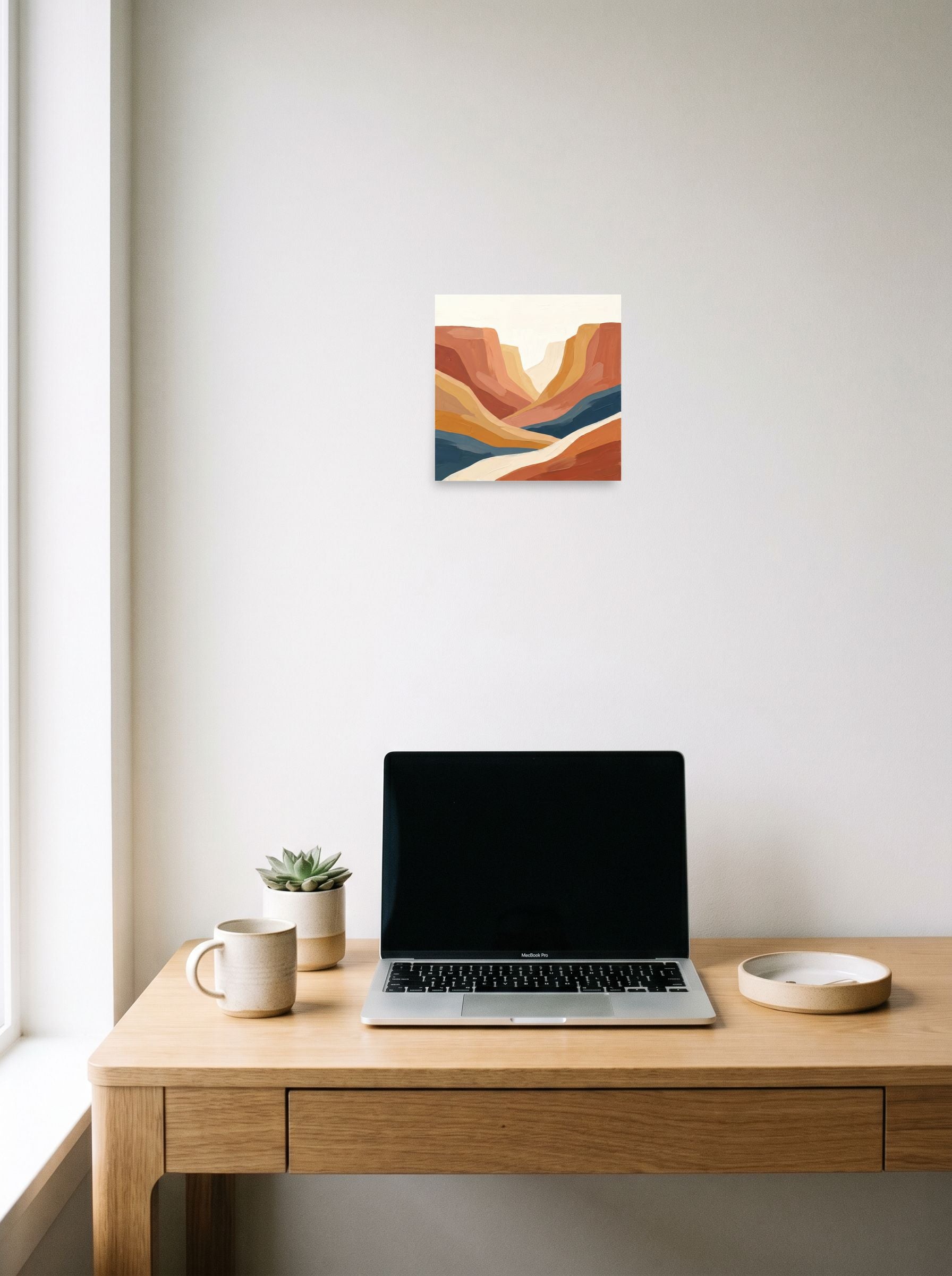 A 10x10 inch unframed paper Minimalism,American Scene Painting print of 'Canyon River' hanging above a worktable with a laptop.