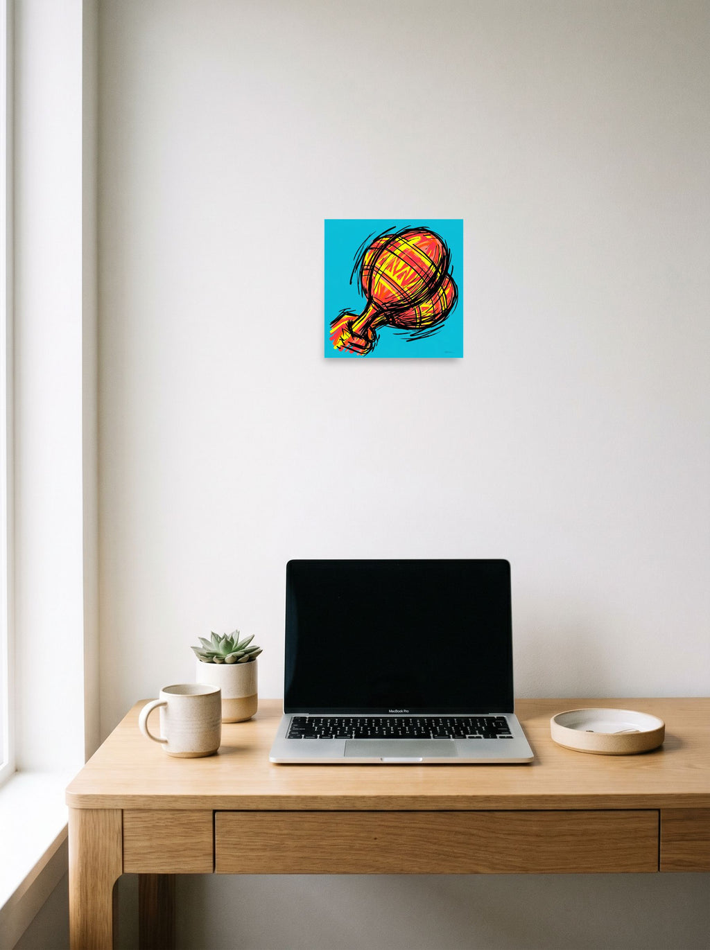 A 10x10 inch unframed paper Pop art print of 'Scribbled Ascent' hanging above a worktable with a laptop.