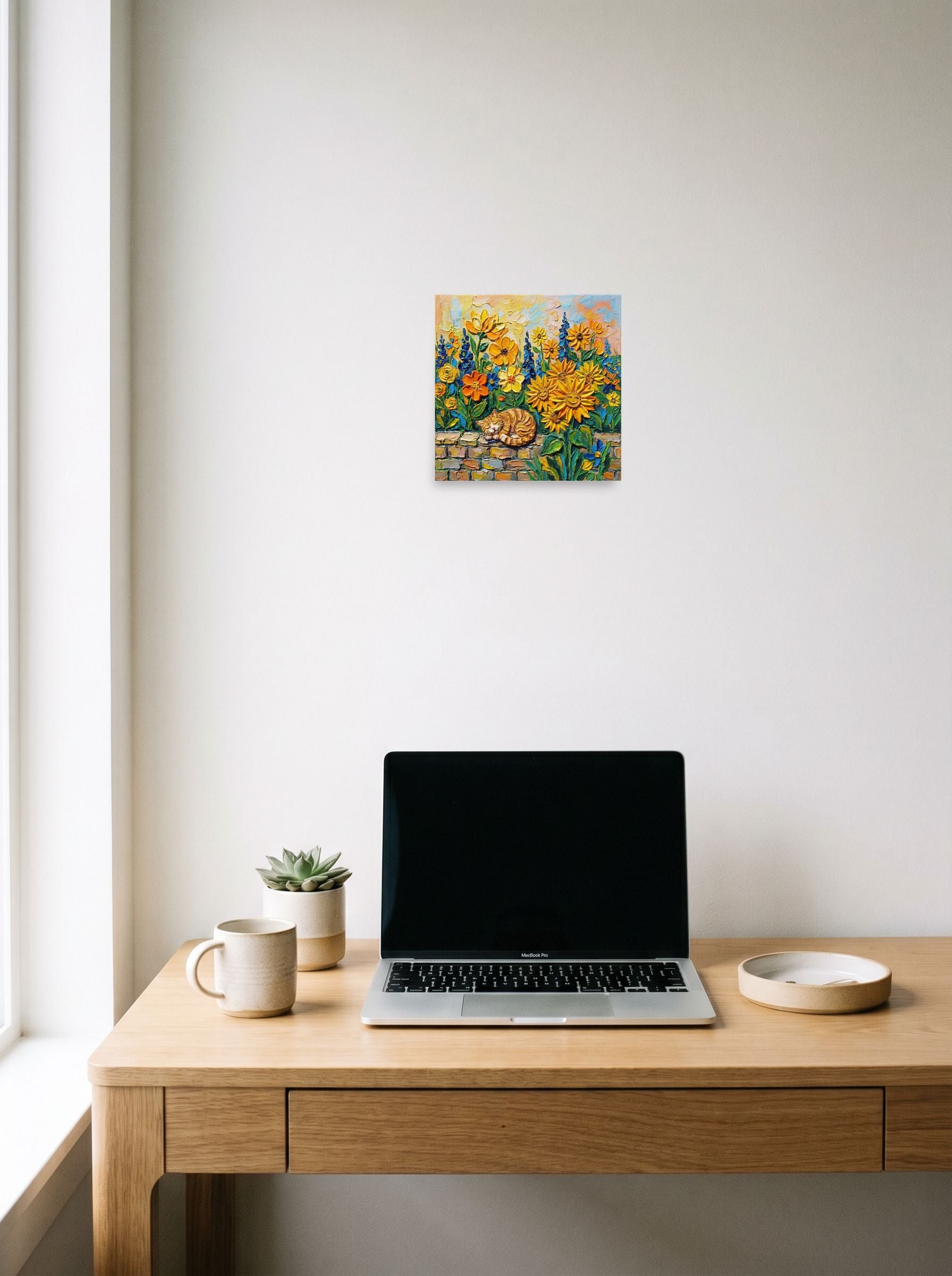 A 10x10 inch unframed paper Post-Impressionism print of 'Feline Slumber Among Sunflowers' hanging above a worktable with a laptop.