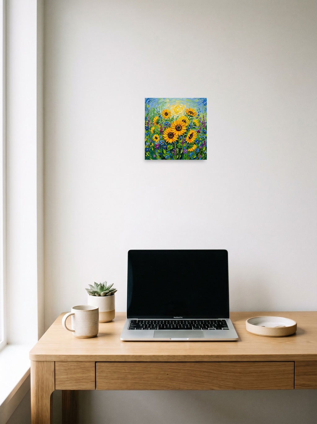 A 10x10 inch unframed paper Impressionism print of 'Sunlit Blooms' hanging above a worktable with a laptop.