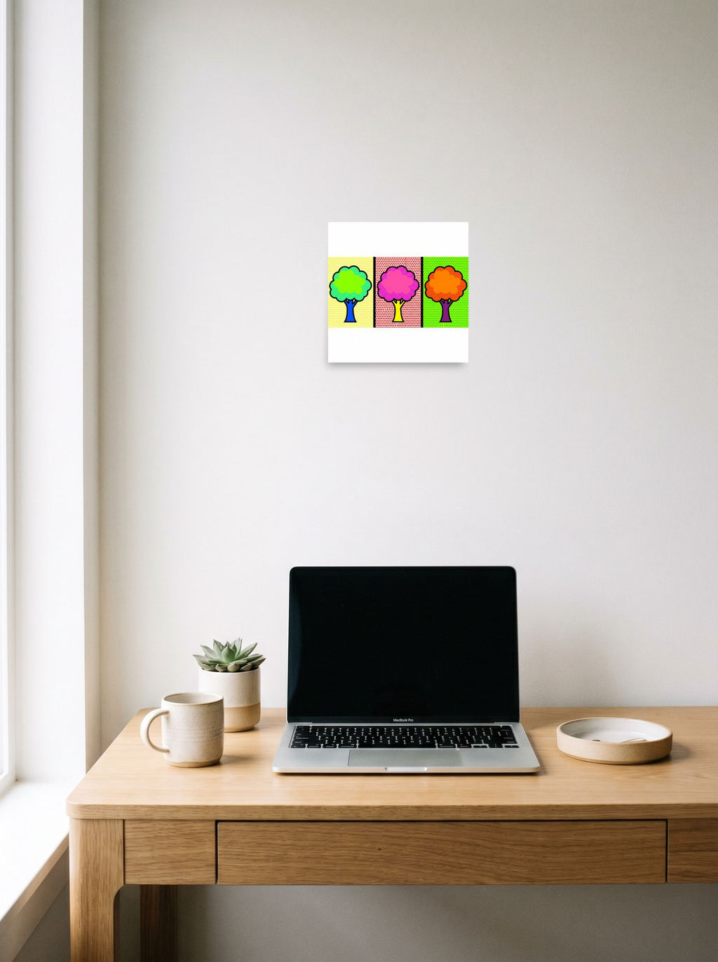 A 10x10 inch unframed paper Pop art print of 'Pop Art Canopy Triptych' hanging above a worktable with a laptop.