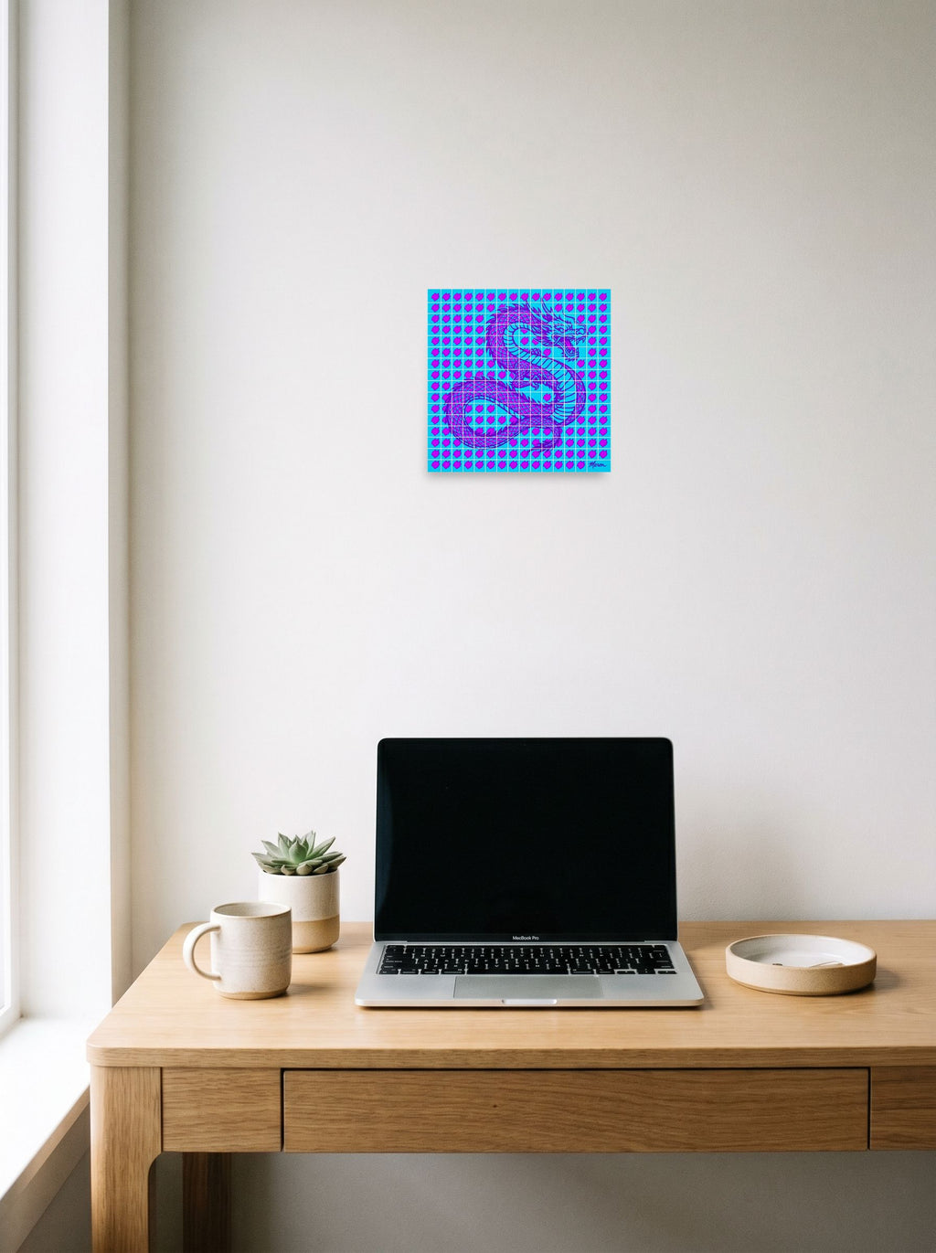 A 10x10 inch unframed paper Pop art print of 'Neon Dragon Grid' hanging above a worktable with a laptop.