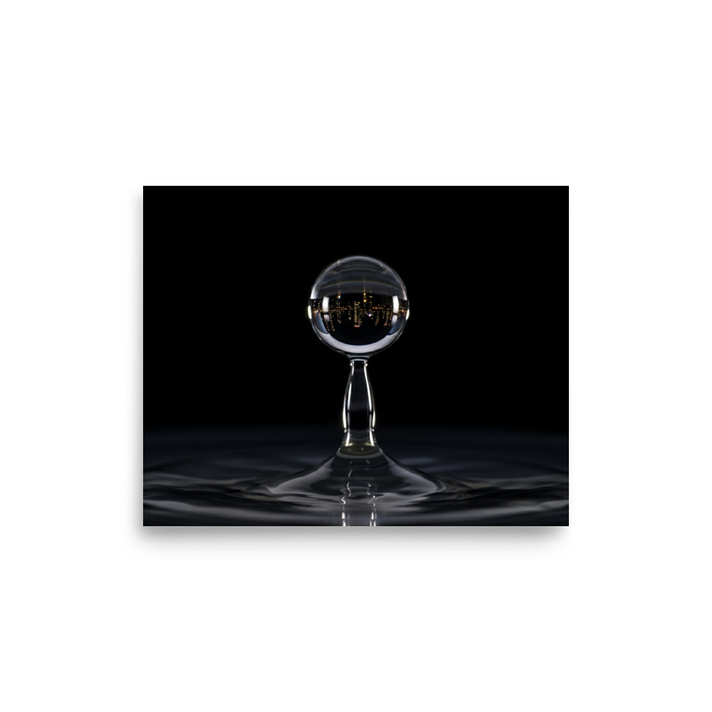 'City in a Drop' — a Surrealism print. A macro view of a water droplet splashing, containing an inverted reflection of a glowing city skyline at night.