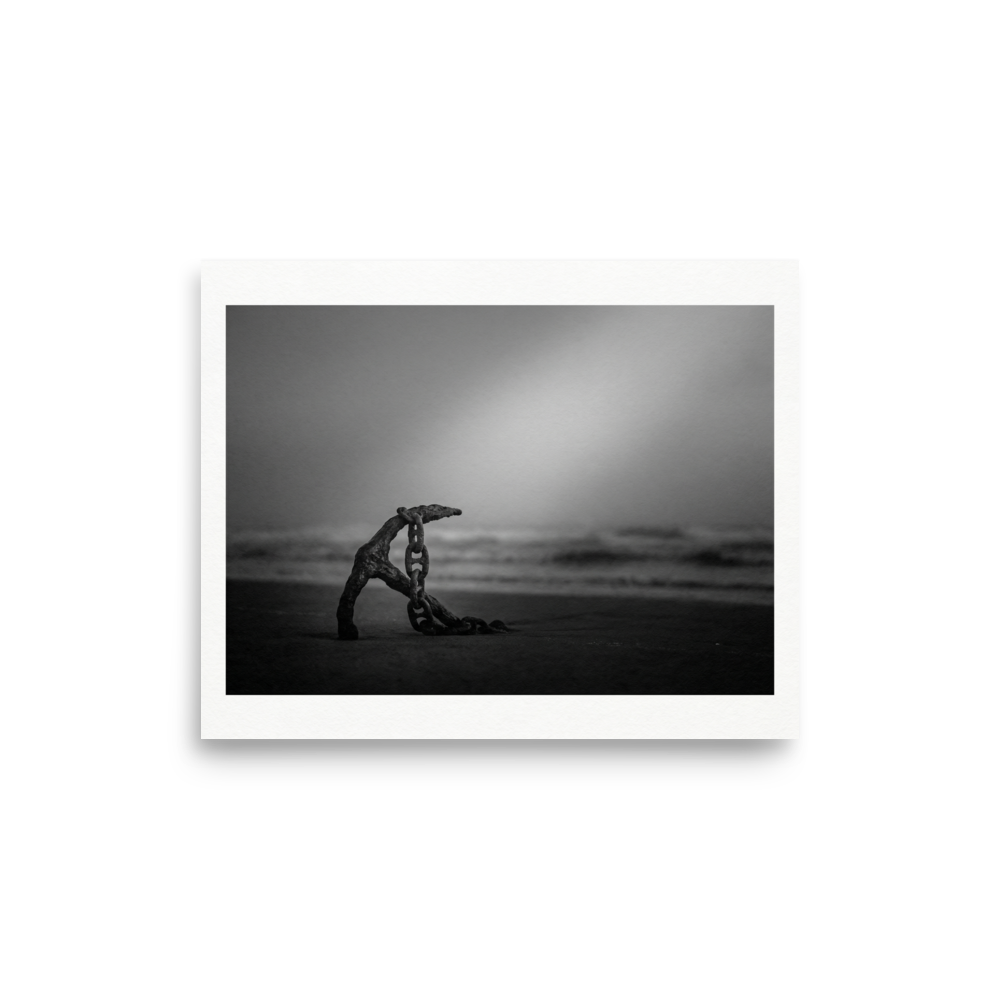 'The Old Anchor' — a Art photography print. A moody black and white photograph of an old rusted anchor and chain resting on a misty beach, a striking nautical piece for a Bathroom.