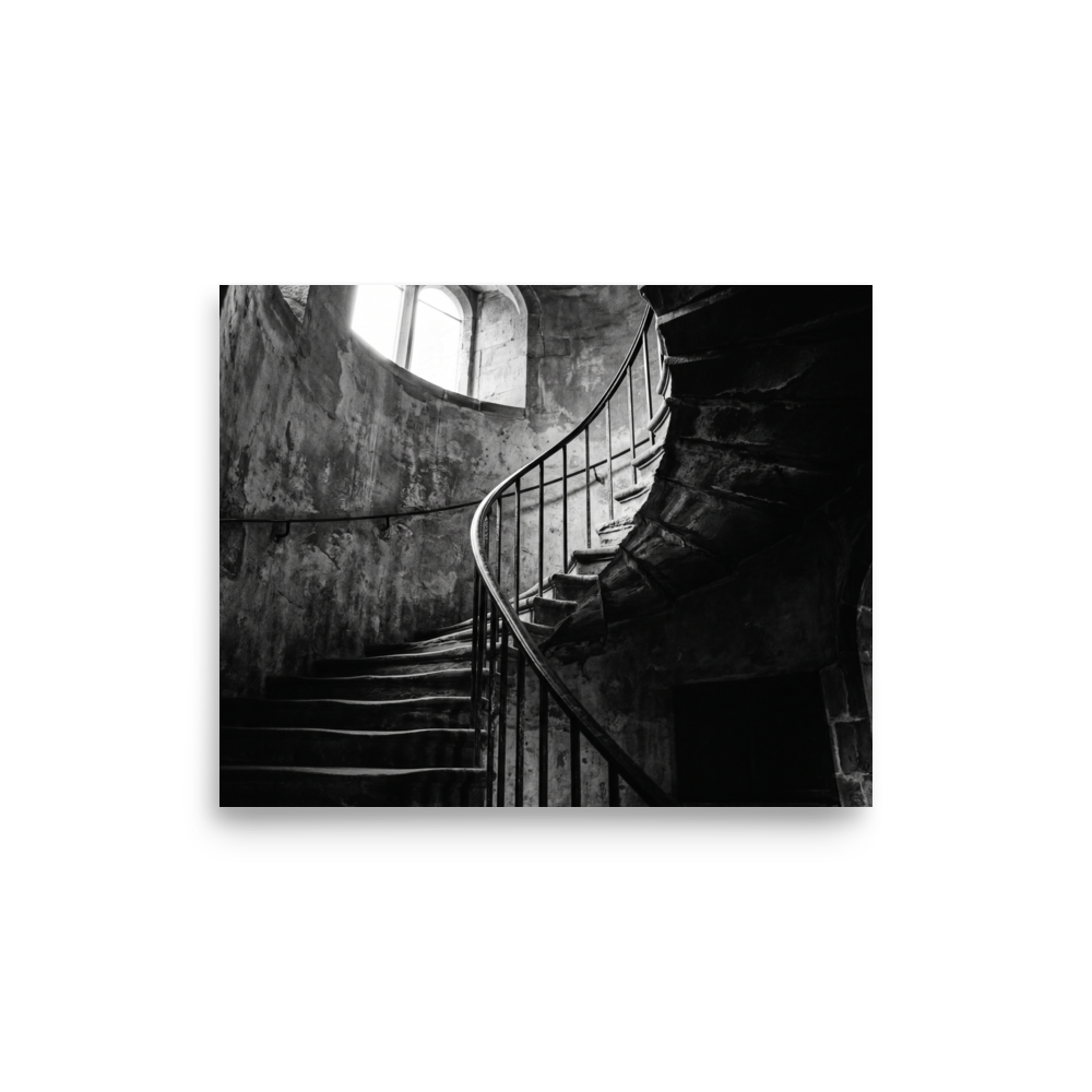 'Ascending Shadows' — a Art photography print. A black and white photograph of a winding stone staircase bathed in dramatic natural light, an elegant focal point for a Hallway.
