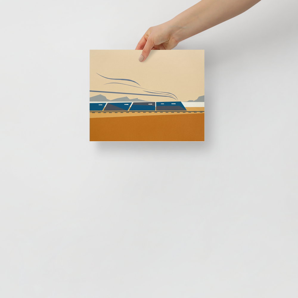 'The Coastal Express' — a Minimalism print. A modern minimalist graphic illustration of a blue train moving across an ochre and beige landscape with grey mountains in the background, ideal for an Office or Boy's Bedroom.
