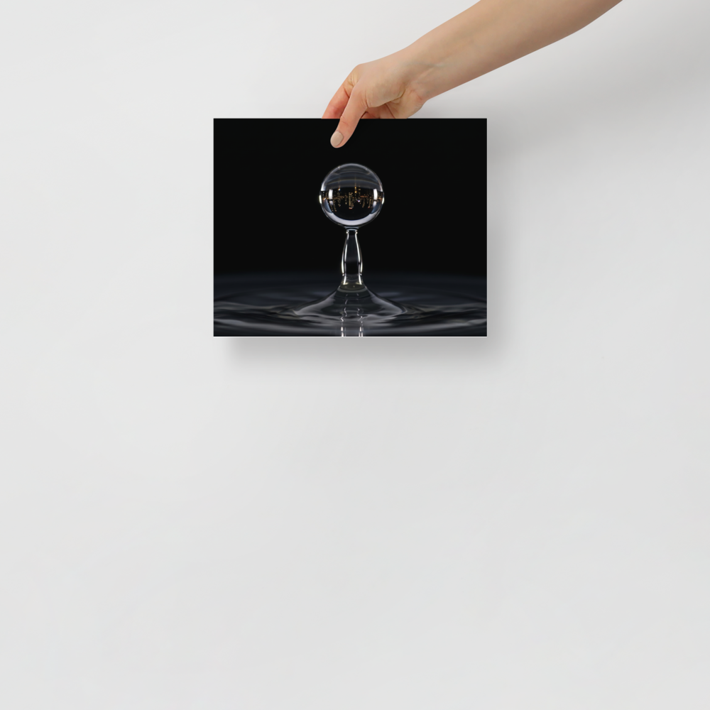 'City in a Drop' — a Surrealism print. A macro view of a water droplet splashing, containing an inverted reflection of a glowing city skyline at night.