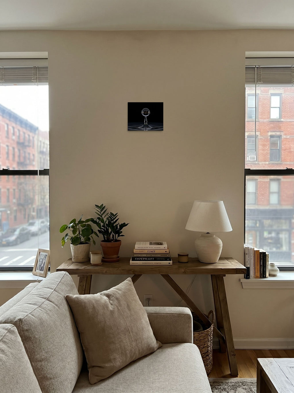 A 10x8 inch unframed paper Surrealism print of 'City in a Drop' displayed in the center of a living room.