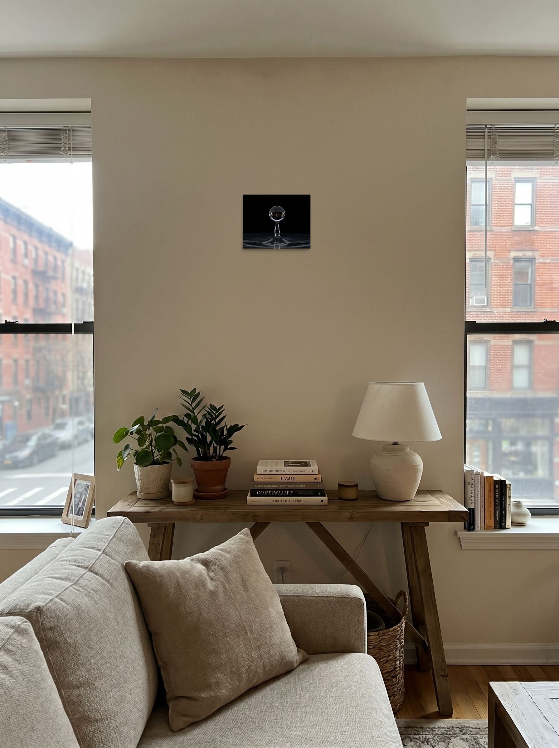 A 10x8 inch unframed paper Surrealism print of 'City in a Drop' displayed in the center of a living room.