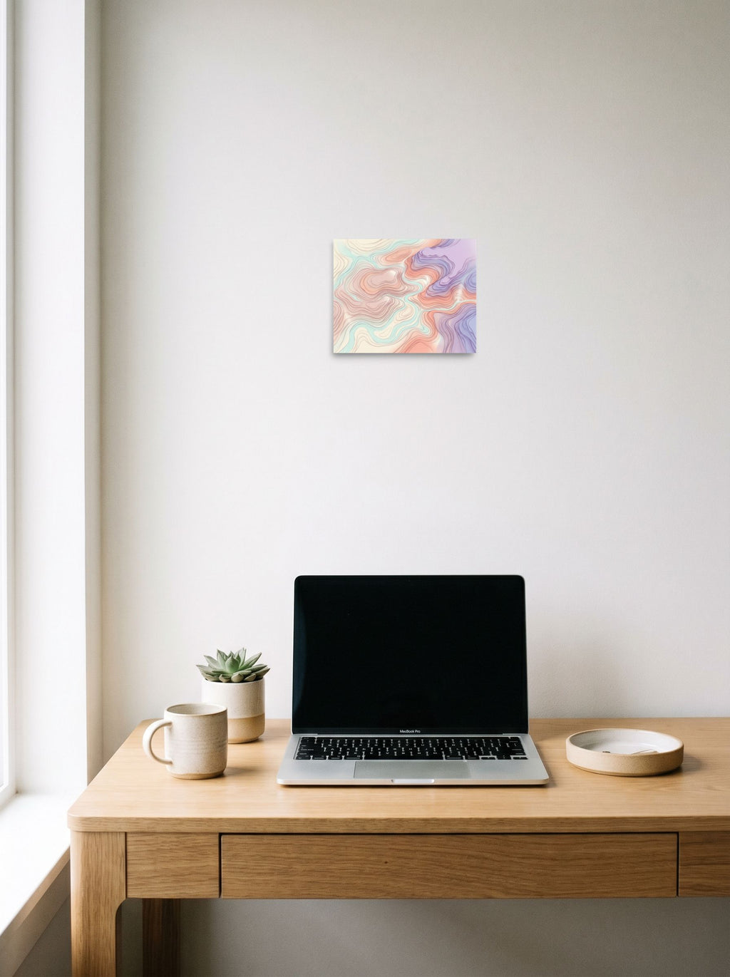 A 10x8 inch unframed paper Abstract art,Geometric abstract art print of 'Pastel Topography' hanging above a worktable with a laptop.