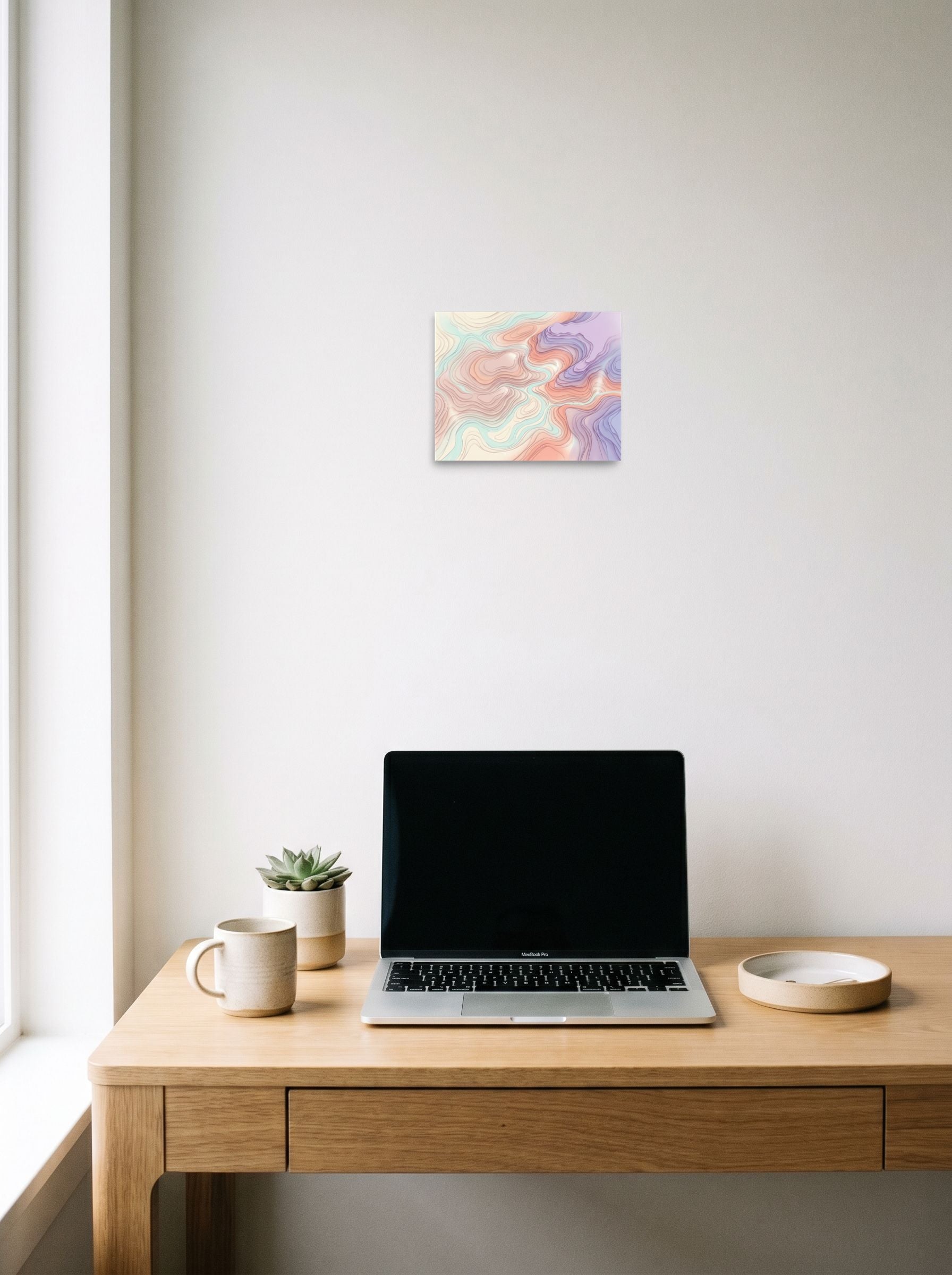 A 10x8 inch unframed paper Abstract art,Geometric abstract art print of 'Pastel Topography' hanging above a worktable with a laptop.