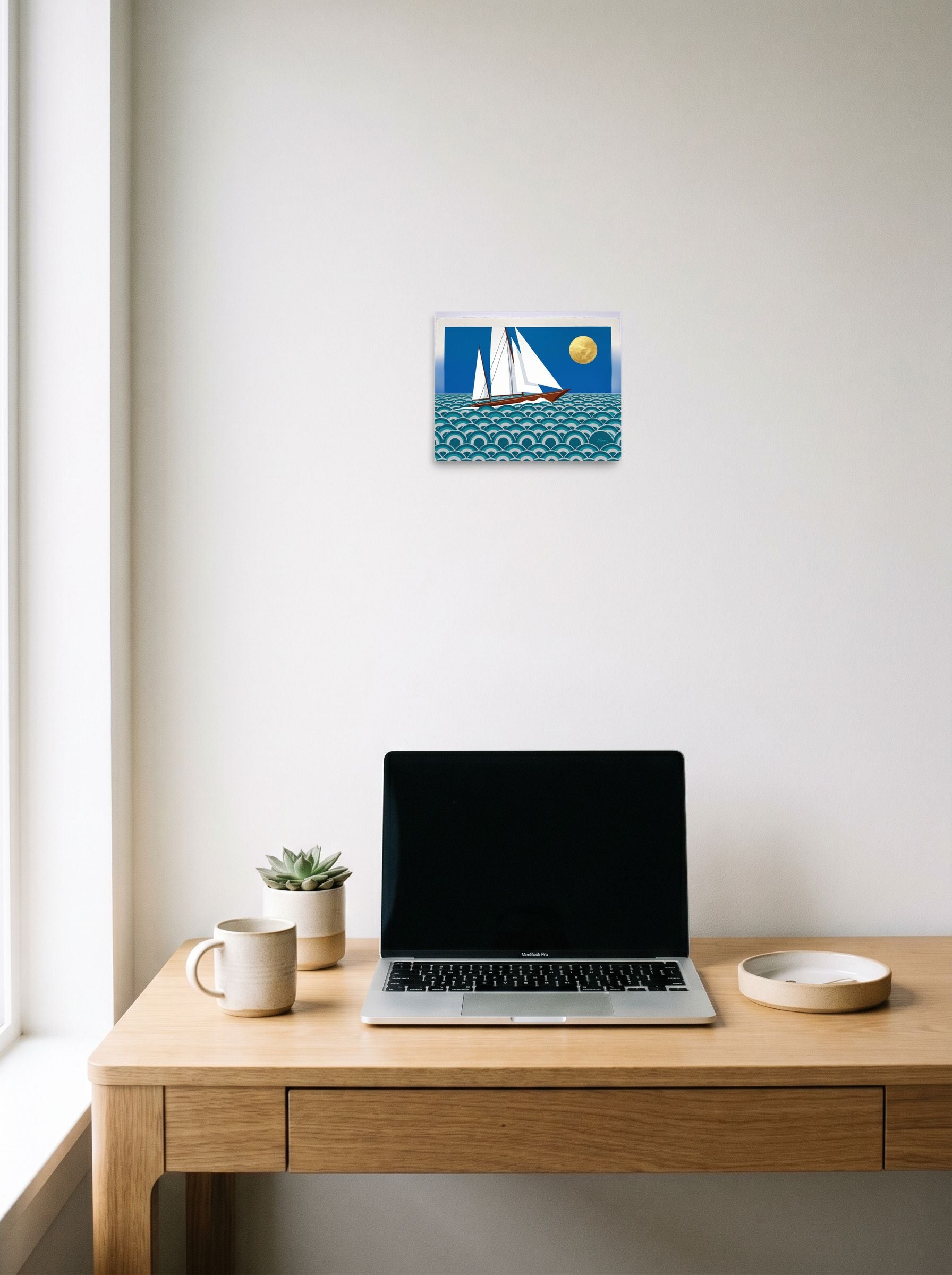 A 10x8 inch unframed paper Art Deco print of 'The Deco Voyage' hanging above a worktable with a laptop.