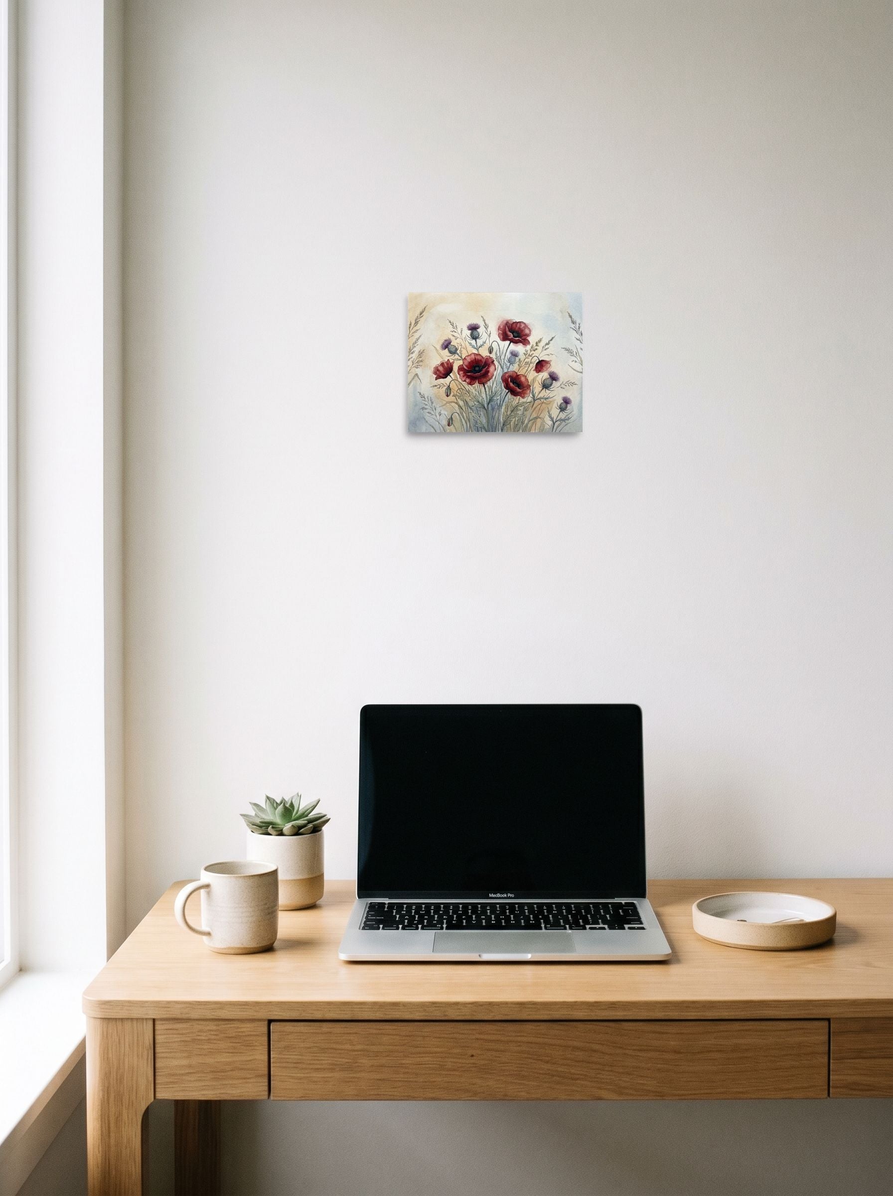 A 10x8 inch unframed paper Realism print of 'Wildflower Medley' hanging above a worktable with a laptop.