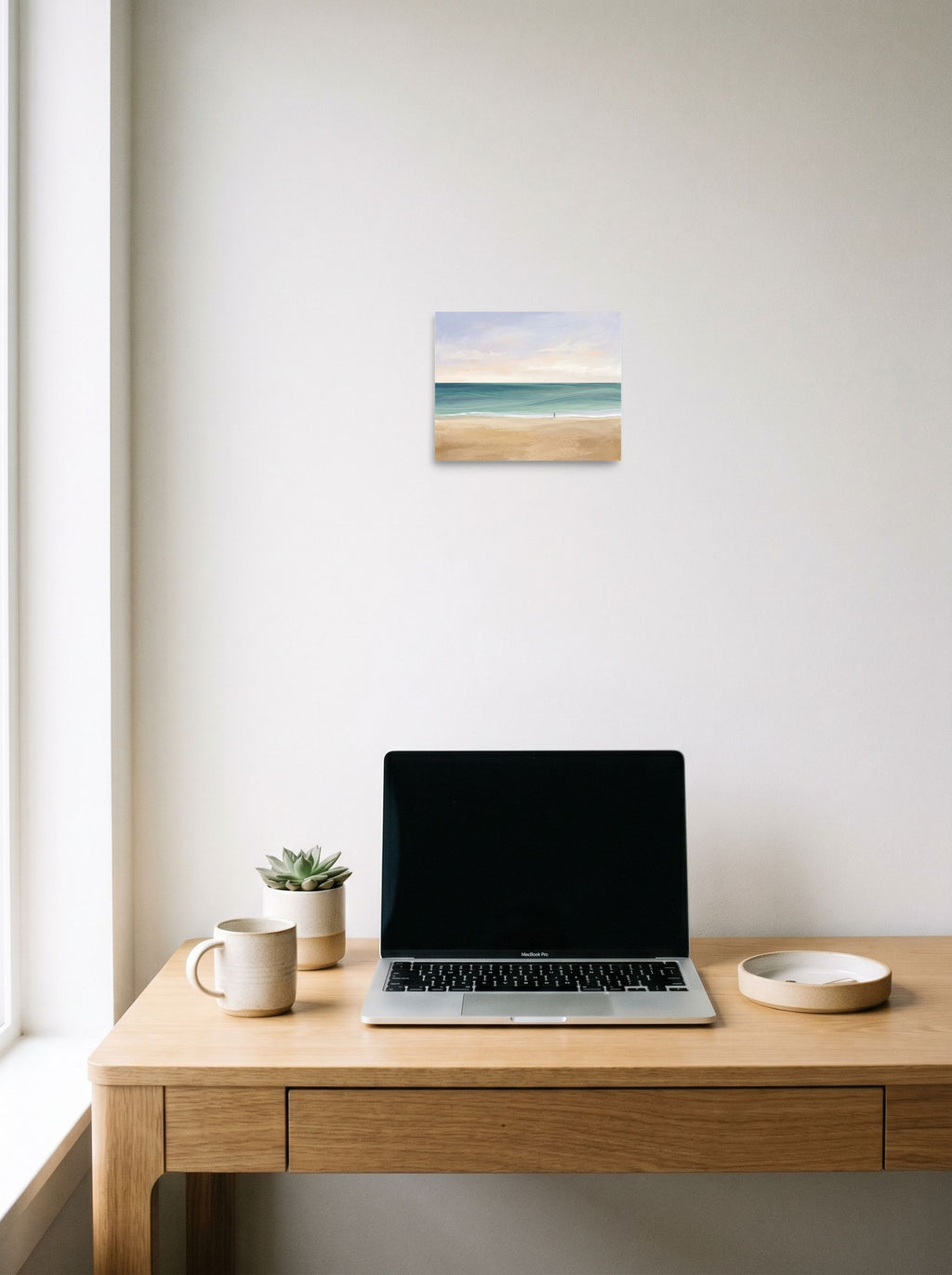 A 10x8 inch unframed paper Minimalism,Impressionism print of 'Solitary Shore' hanging above a worktable with a laptop.
