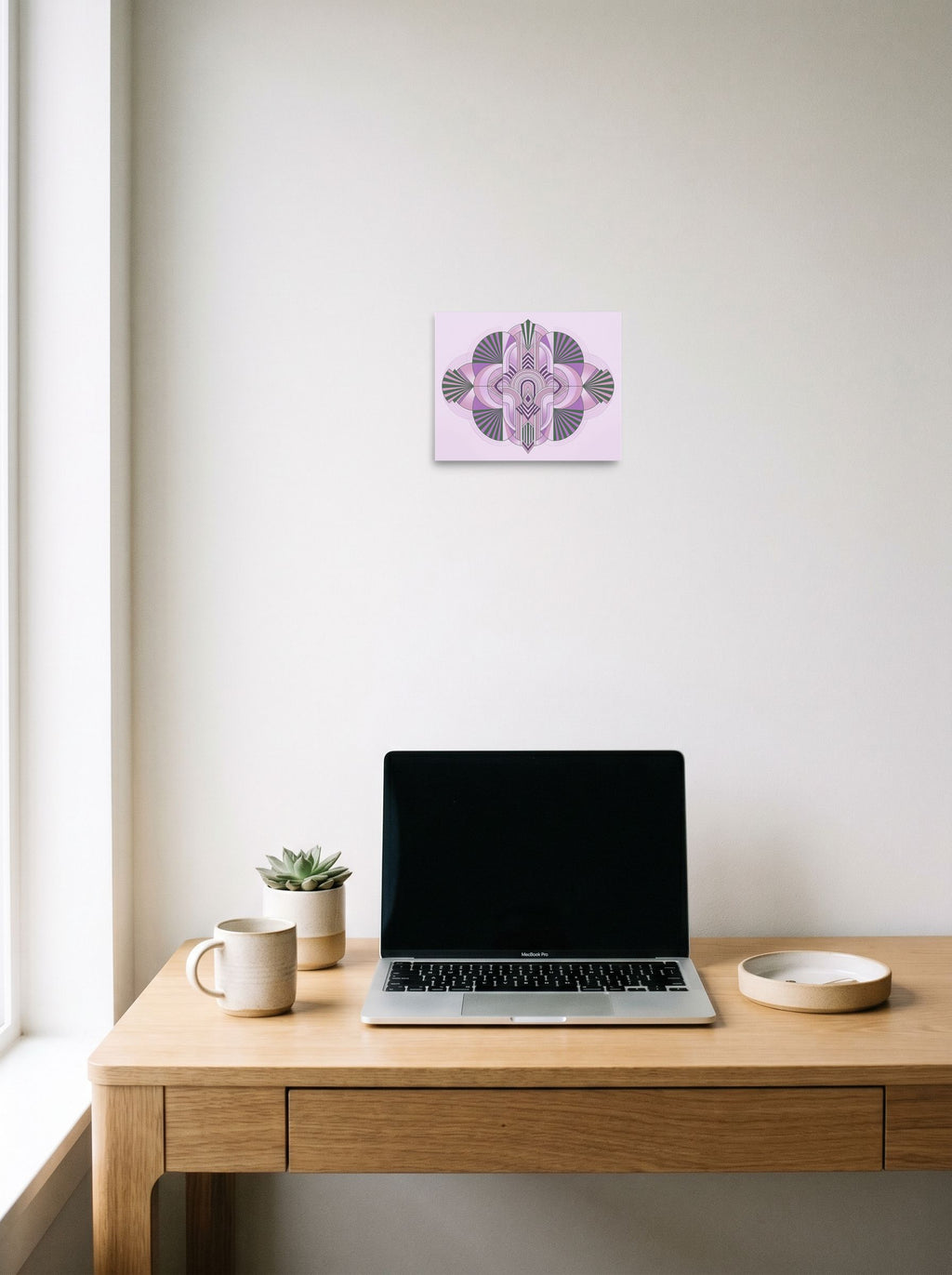 A 10x8 inch unframed paper Art Deco print of 'Lavender Deco Symmetry' hanging above a worktable with a laptop.