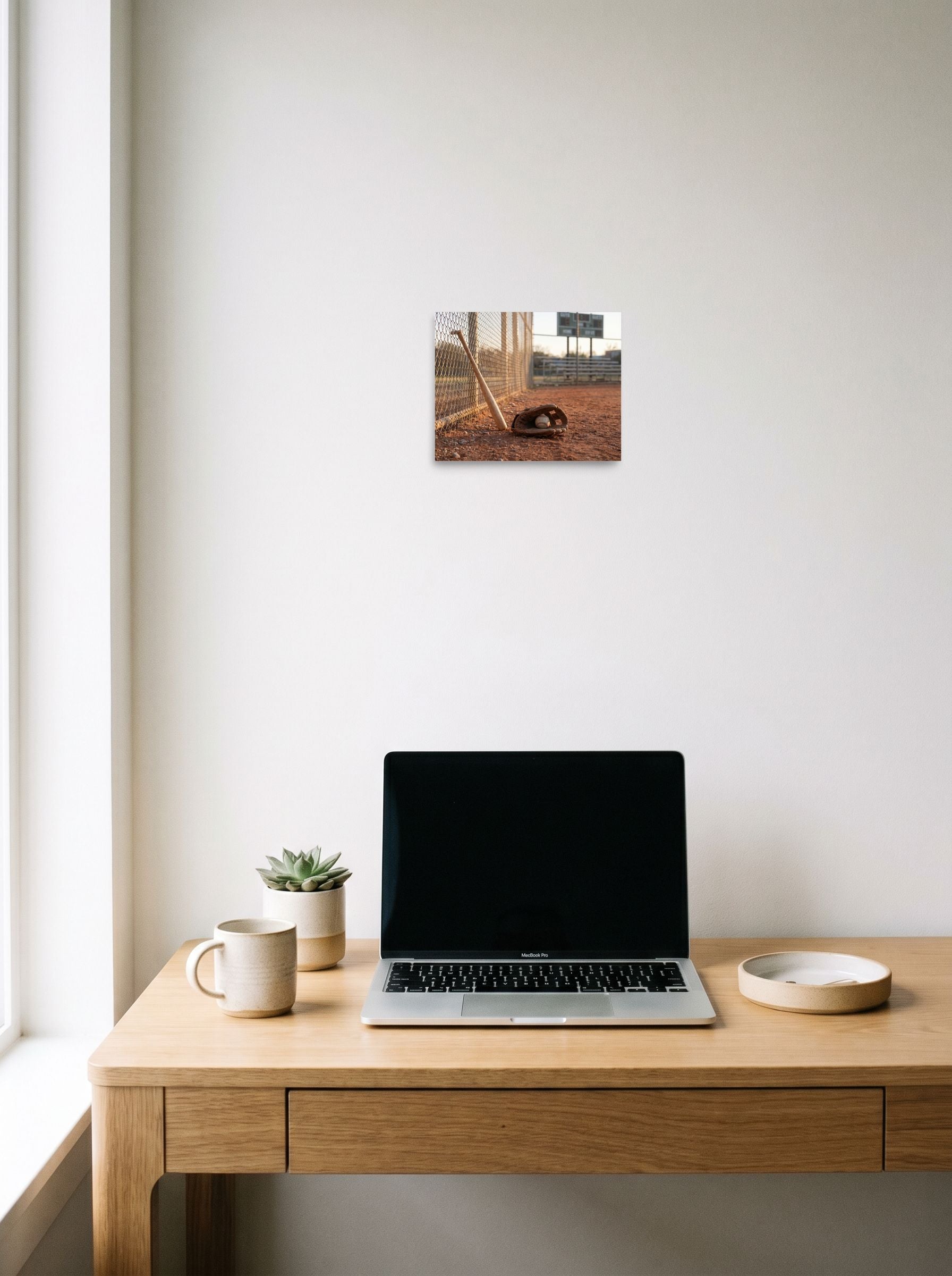 A 10x8 inch unframed paper Art photography print of 'Field of Memories' hanging above a worktable with a laptop.