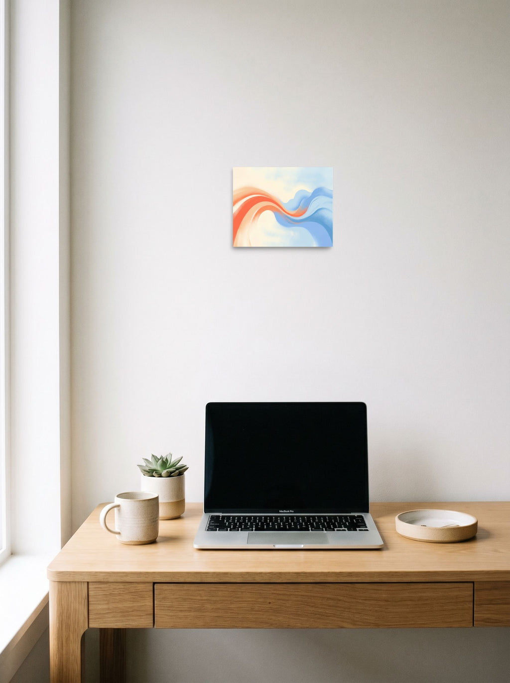 A 10x8 inch unframed paper Abstract art print of 'Soft Serenade' hanging above a worktable with a laptop.