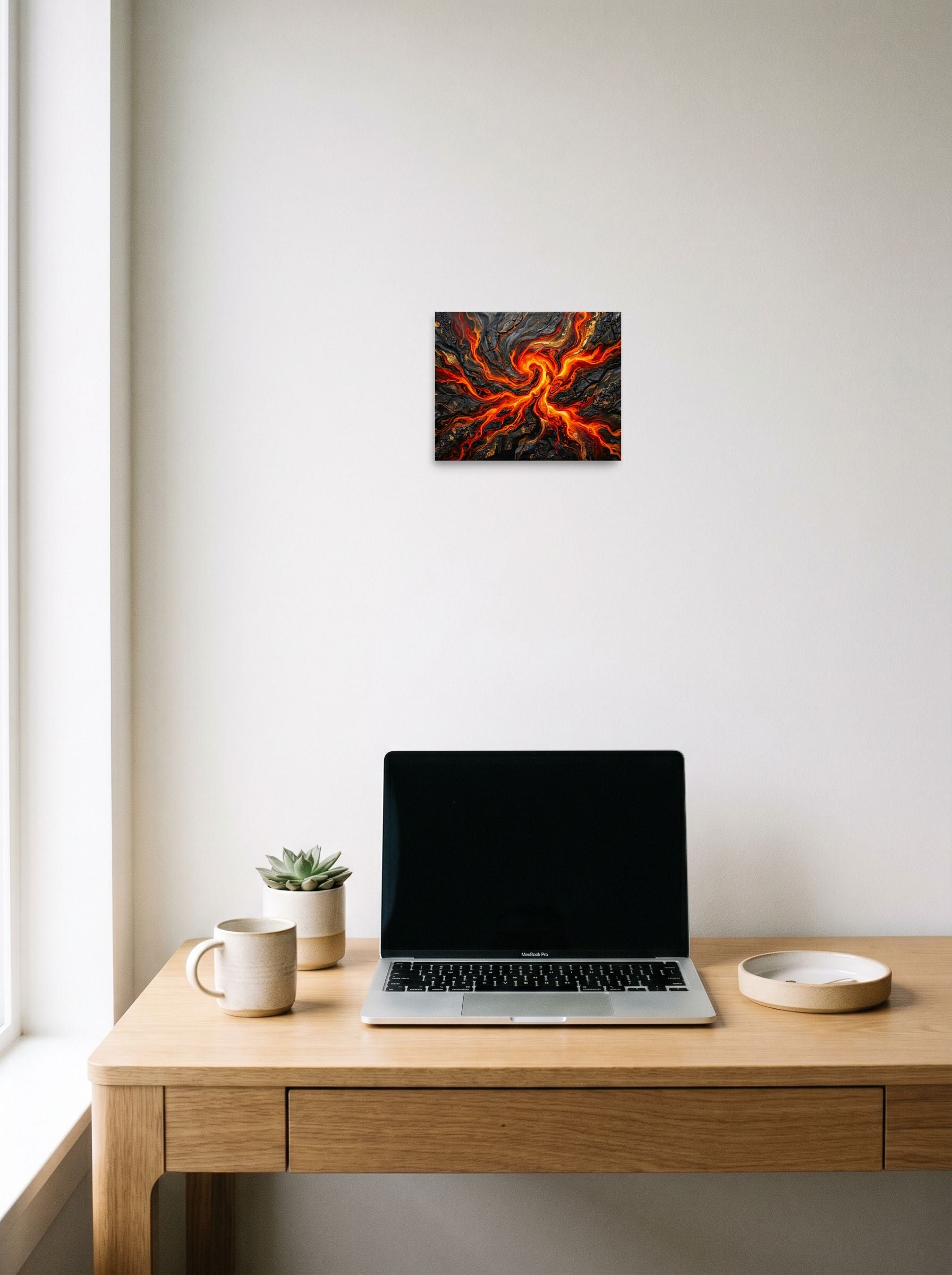 A 10x8 inch unframed paper Abstract art print of 'Molten Core' hanging above a worktable with a laptop.