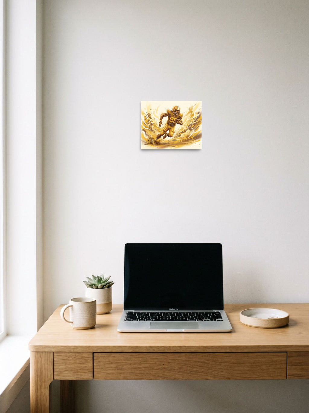 A 10x8 inch unframed paper Figurative art print of 'Golden Gridiron' hanging above a worktable with a laptop.