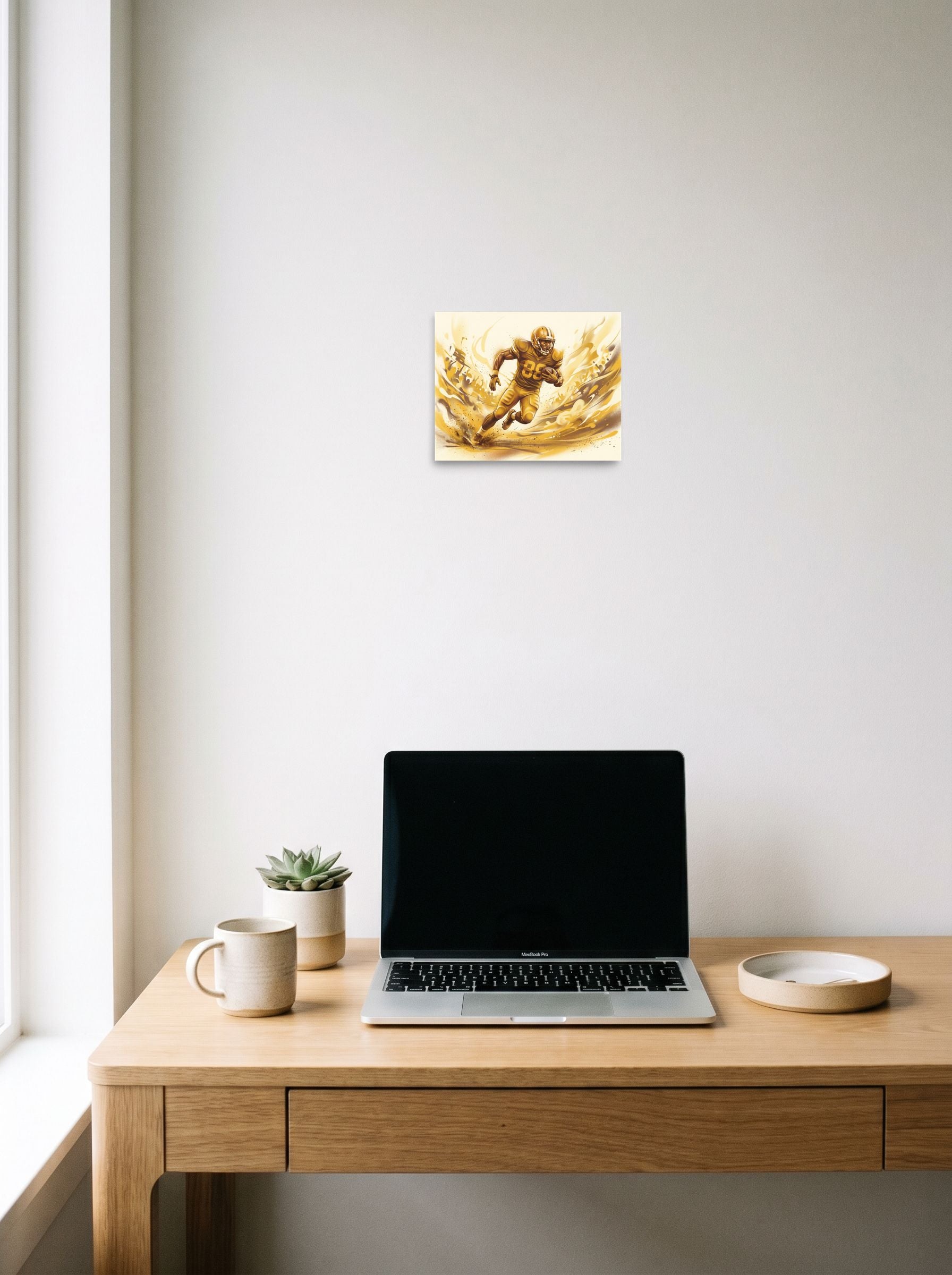 A 10x8 inch unframed paper Figurative art print of 'Golden Gridiron' hanging above a worktable with a laptop.