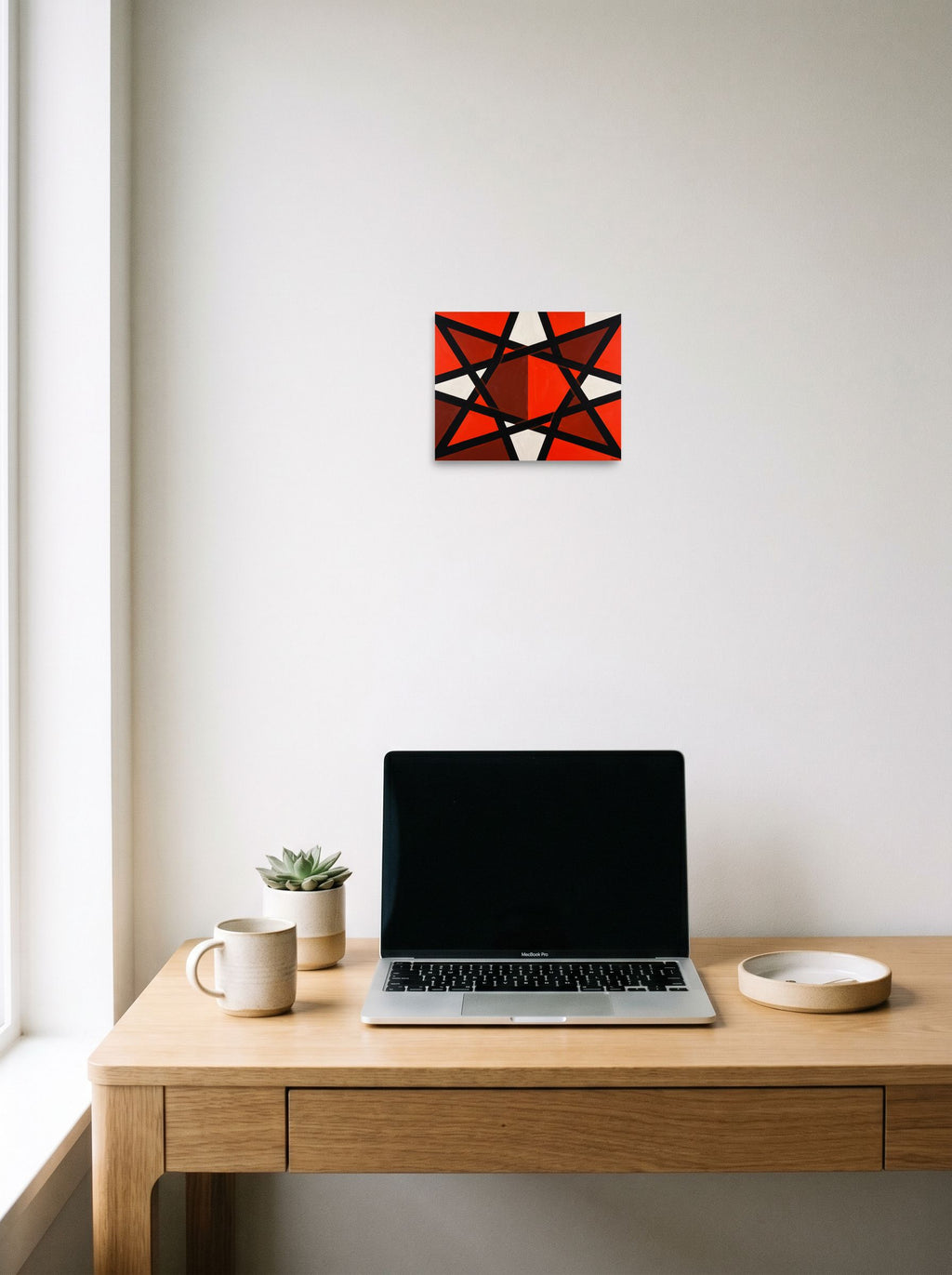 A 10x8 inch unframed paper Constructivism print of 'Prismatic Intersect', displayed over a compact desk setup.