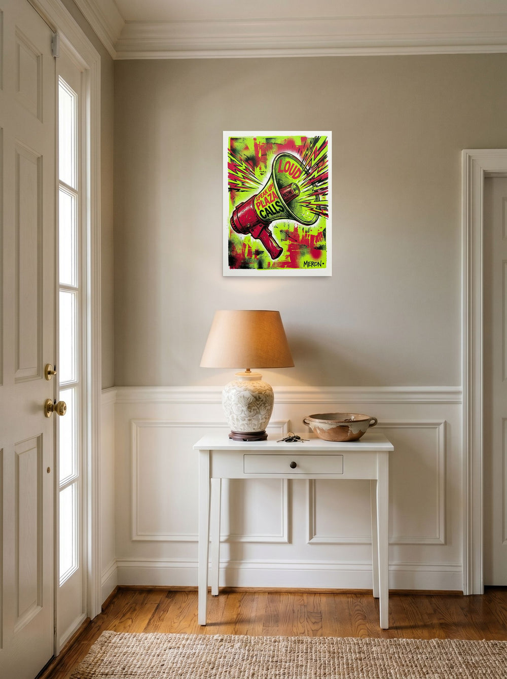 A 18x24 inch unframed paper Pop art print of 'Loud & Clear' hanging in an entryway near a console.