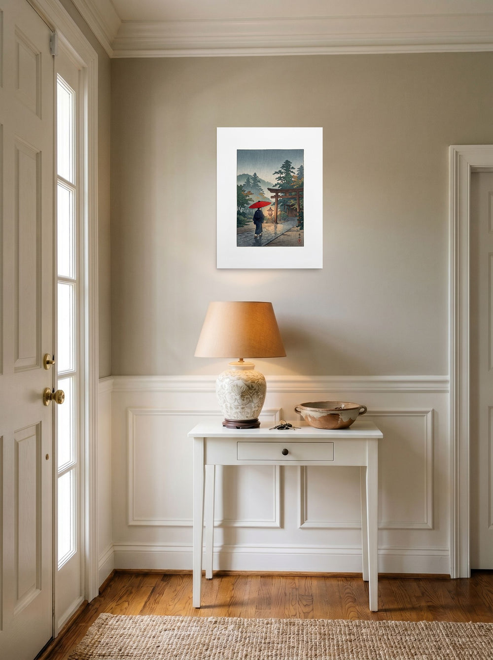 A 18x24 inch unframed paper version of 'Sanctuary in the Rain', Shin hanga wall art, styled above a console table in an entryway.