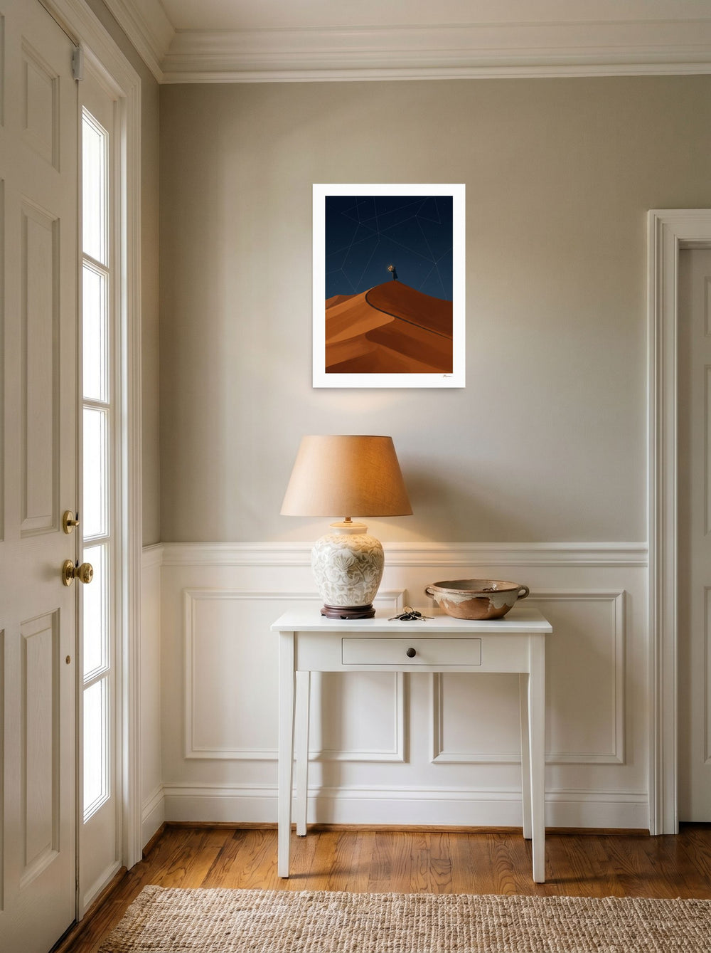 18x24 inch unframed paper print of 'The Desert Astronomer', hanging in an entryway near a console.