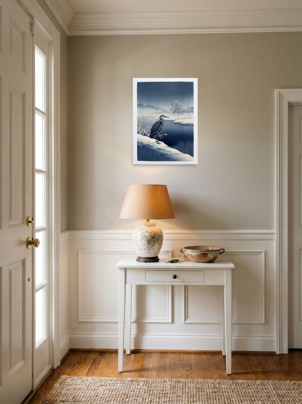 A 18x24 inch unframed paper Shin hanga print of 'Winter Heron' hanging in an entryway near a console.