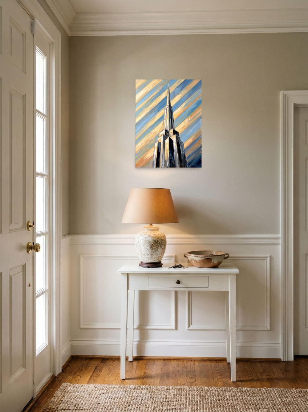 A 18x24 inch unframed paper Art Deco print of 'The Metropolis Spire' hanging in an entryway near a console.