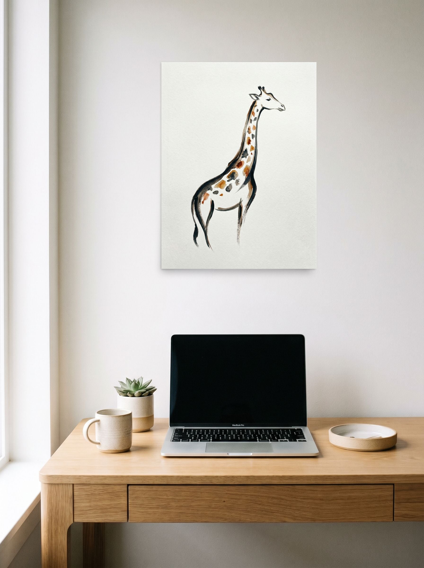 A 18x24 inch unframed paper Minimalism print of 'The Tall Gent' hanging above a worktable with a laptop.