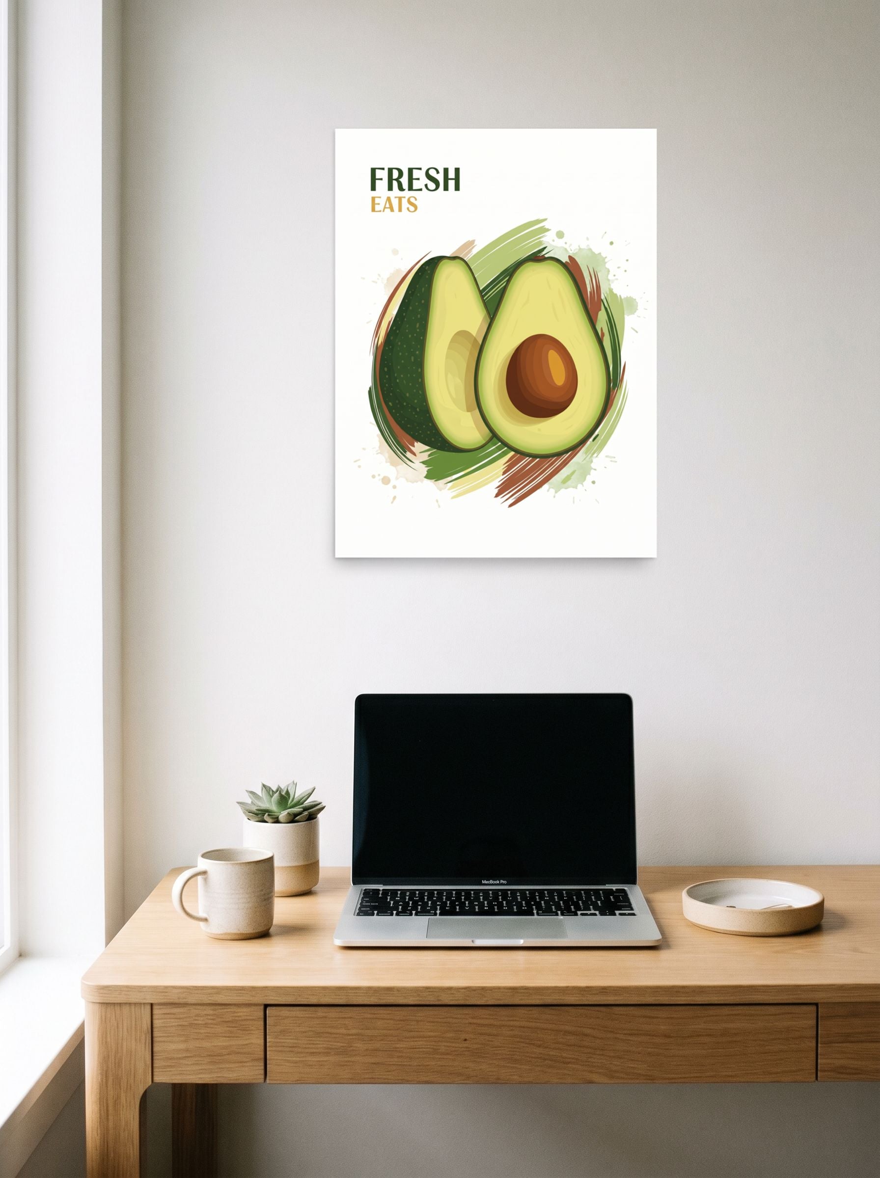 A 18x24 inch unframed paper Pop art,Digital art print of 'Fresh Eats Avocado' hanging above a worktable with a laptop.