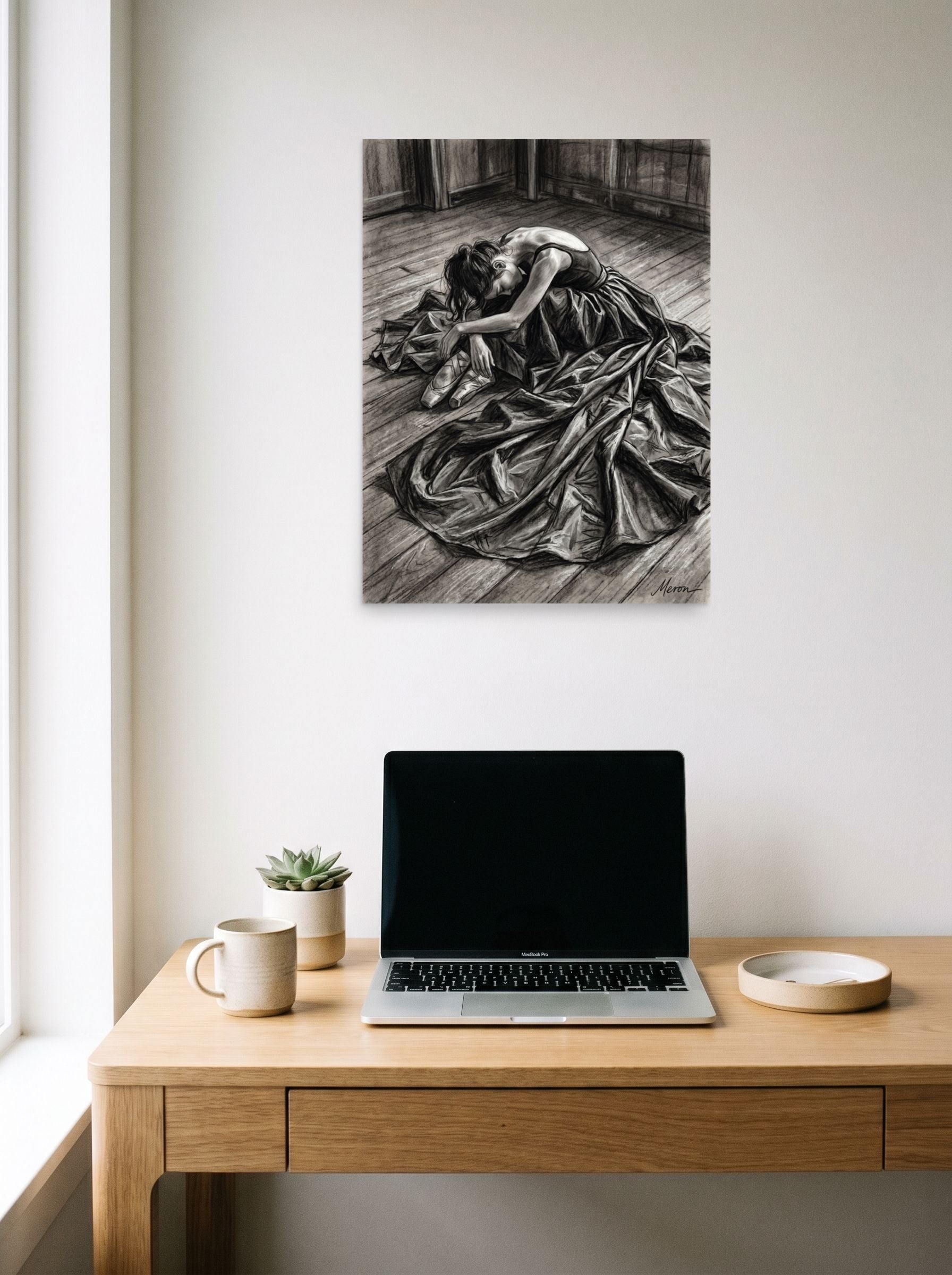 A 18x24 inch unframed paper Realism,Figurative art print of 'Quiet Exhaustion' hanging above a worktable with a laptop.