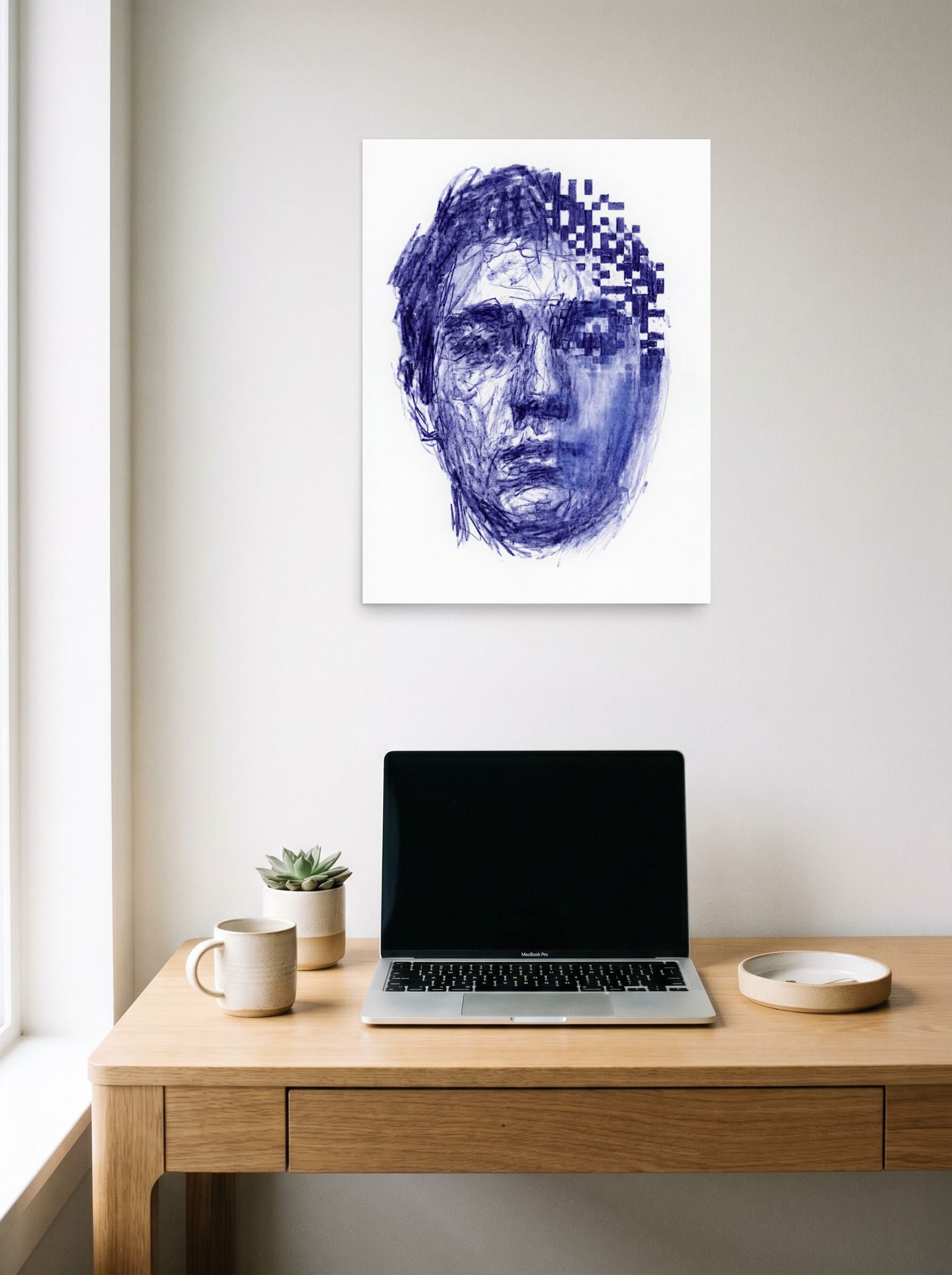 A 18x24 inch unframed paper Glitch art,Surrealism print of 'Digital Dissolution' hanging above a worktable with a laptop.