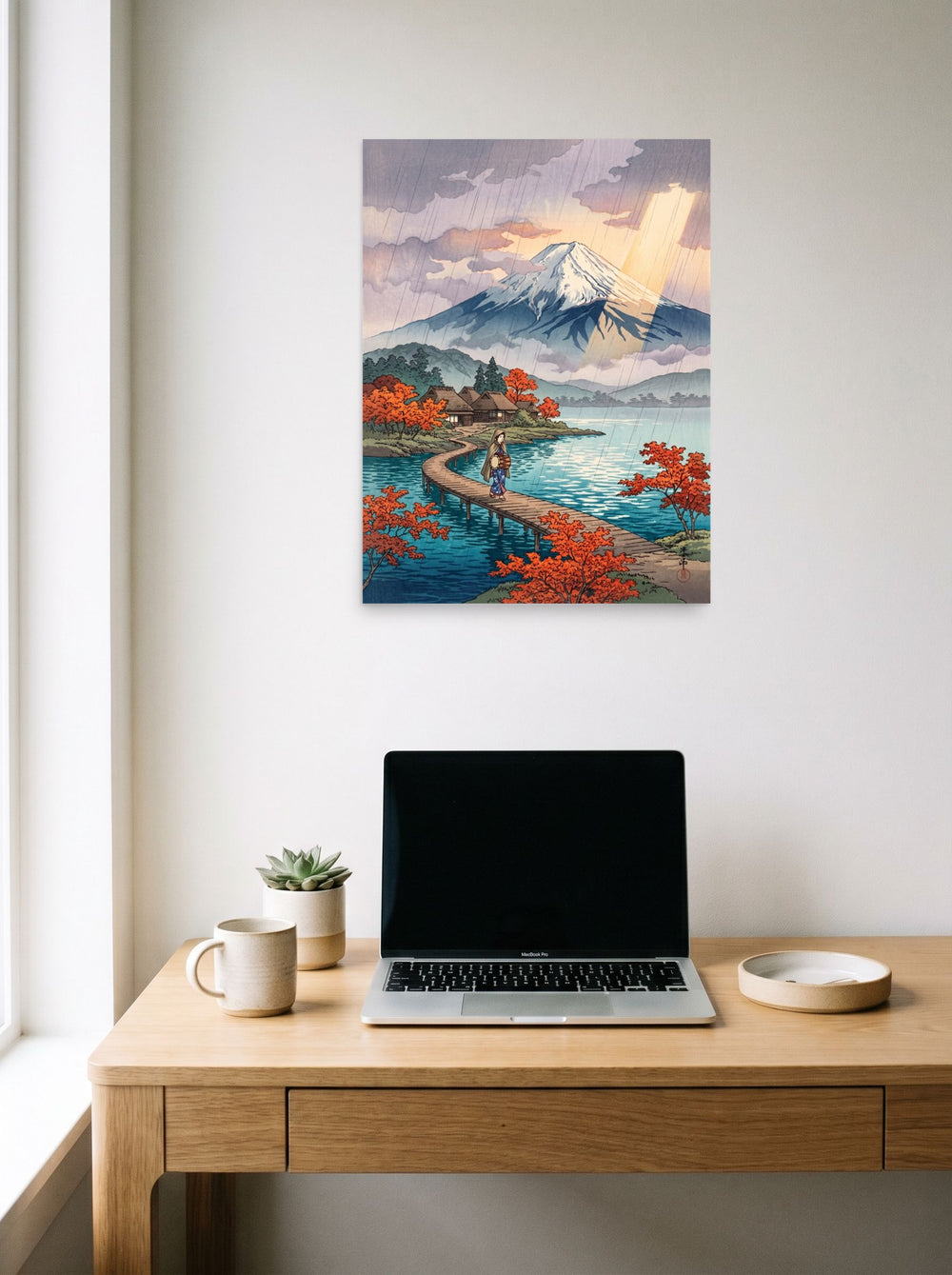A 18x24 inch unframed paper Shin hanga print of 'Sunshower Over Fuji' hanging above a worktable with a laptop.