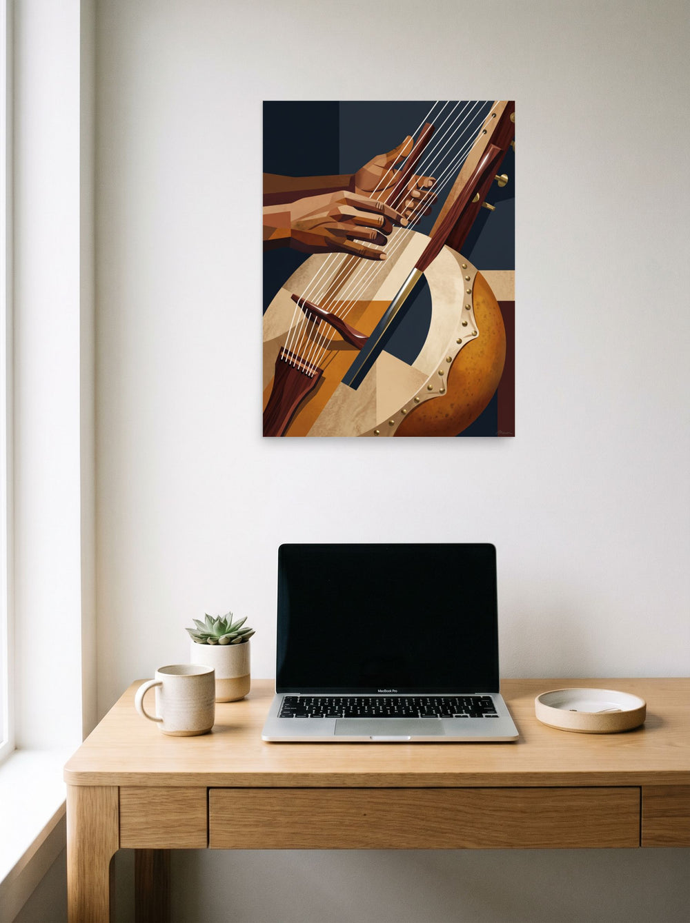 A 18x24 inch unframed paper Cubism print of 'Faceted Kora Melodies', hanging above a worktable with a laptop.