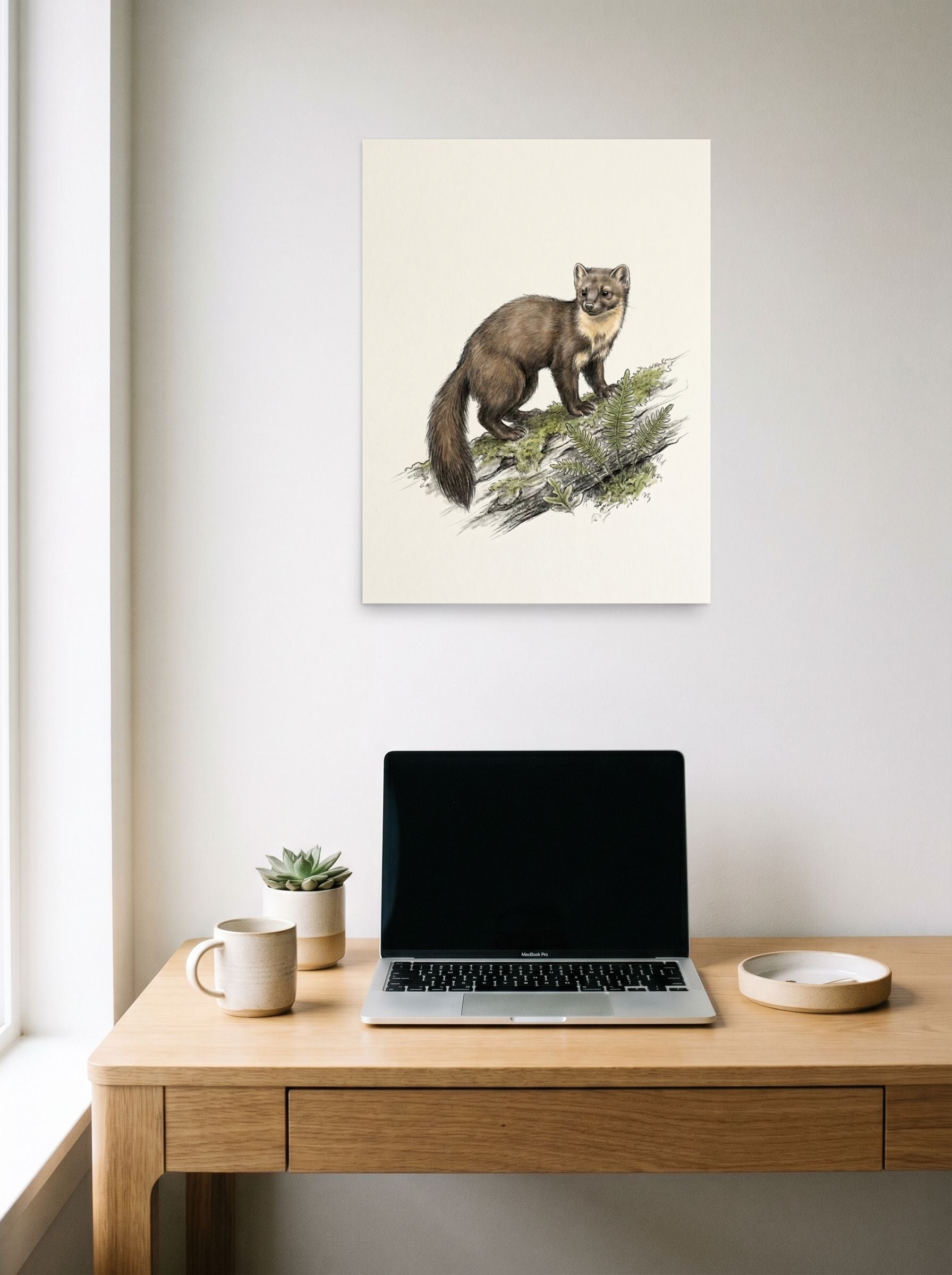 A 18x24 inch unframed paper Academic art,Realism print of 'Pine Marten on a Log' hanging above a worktable with a laptop.