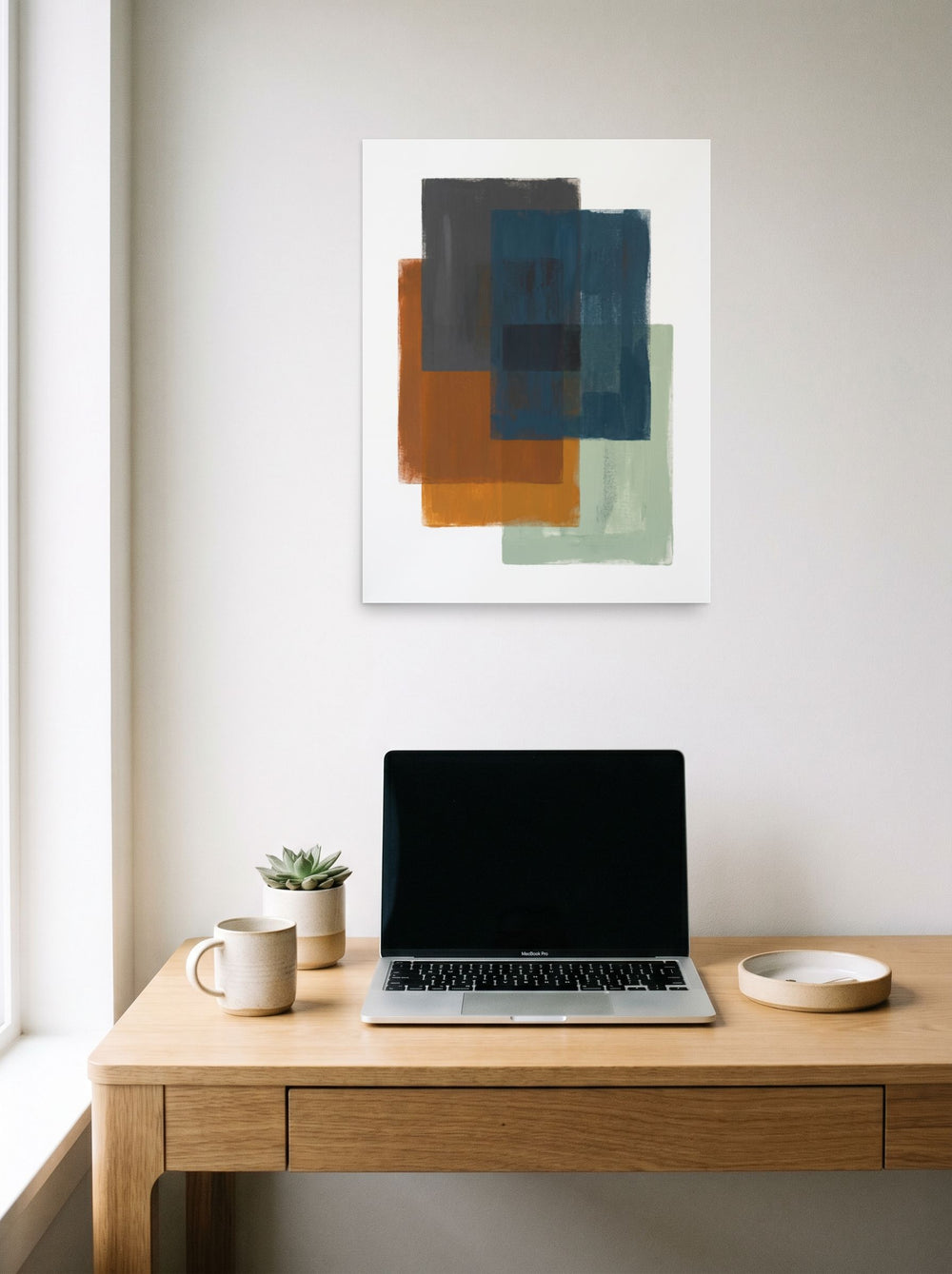 A 18x24 inch unframed paper Minimalism,Color Field print of 'Overlapping Horizons' hanging above a worktable with a laptop.
