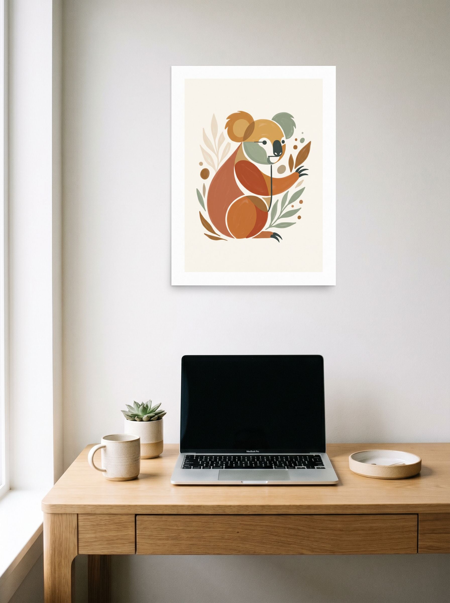 A 18x24 inch unframed paper Minimalism,Abstract art print of 'Geometric Koala Bear' hanging above a worktable with a laptop.