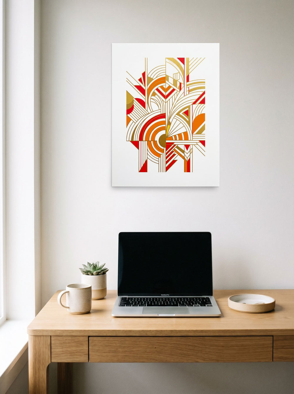 A 18x24 inch unframed paper Art Deco print of 'Radiant Deco Abstract' hanging above a worktable with a laptop.