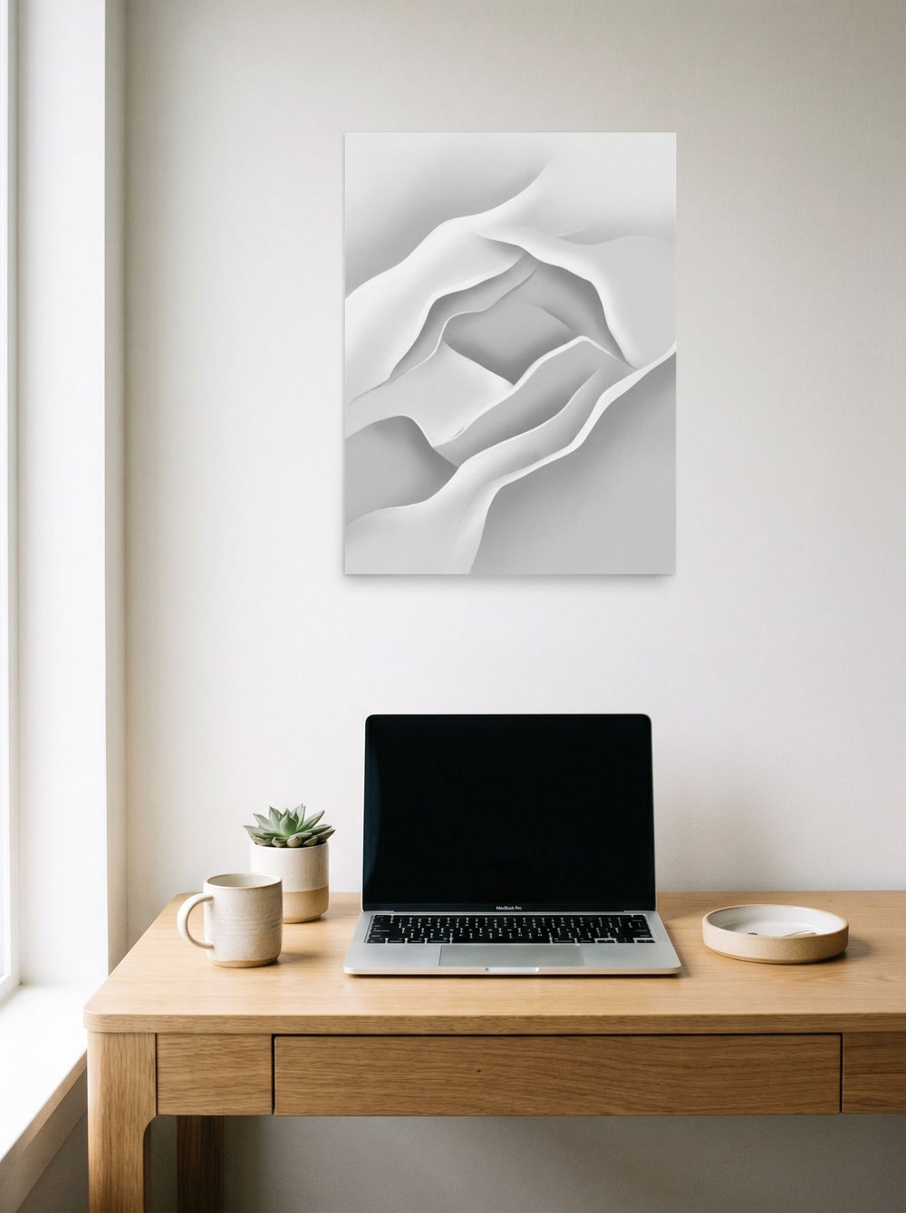 A 18x24 inch unframed paper Minimalism print of 'White Silence' hanging above a worktable with a laptop.