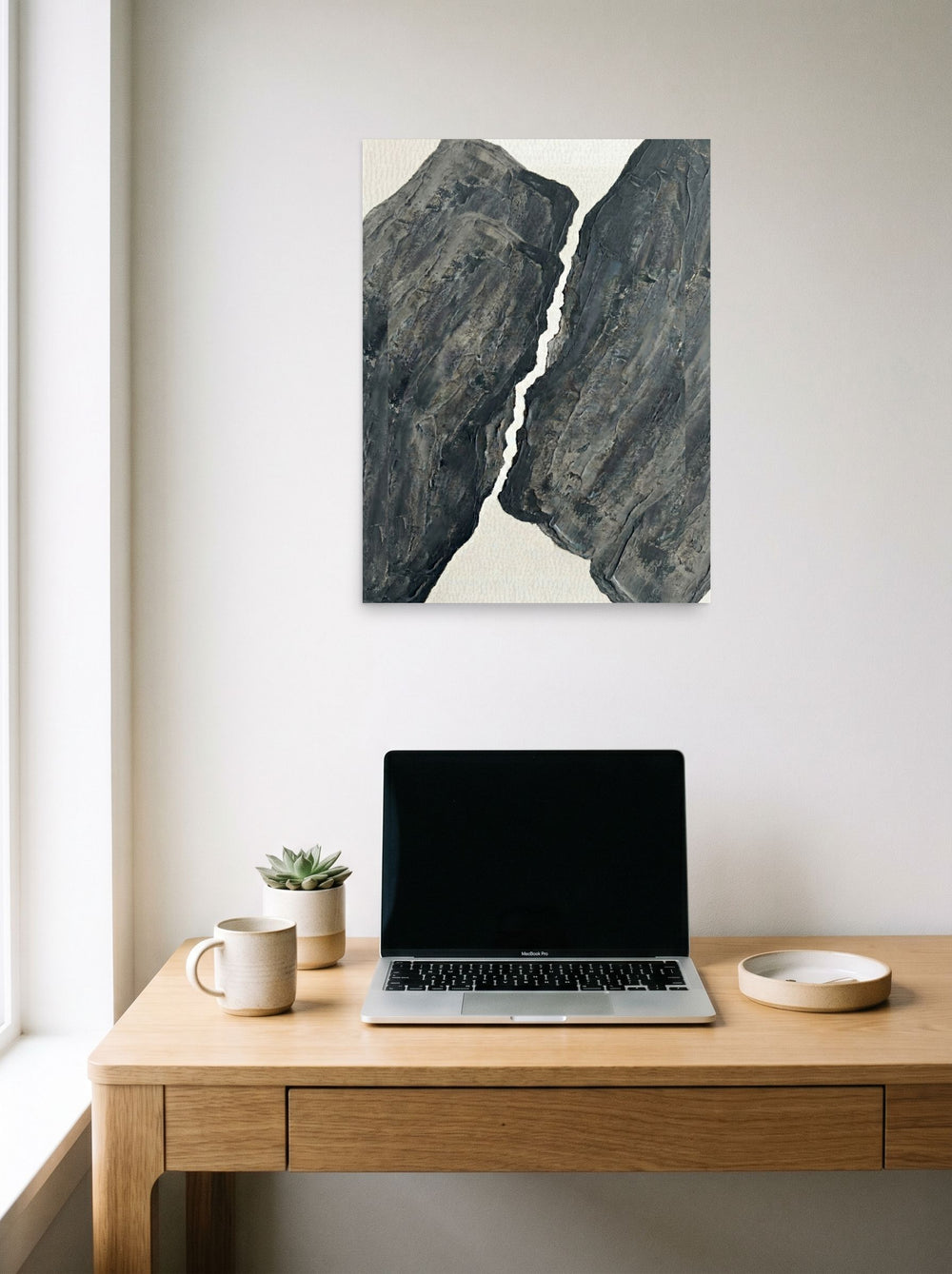 A 18x24 inch unframed paper Abstract art,Minimalism print of 'Fractured Slate' hanging above a worktable with a laptop.