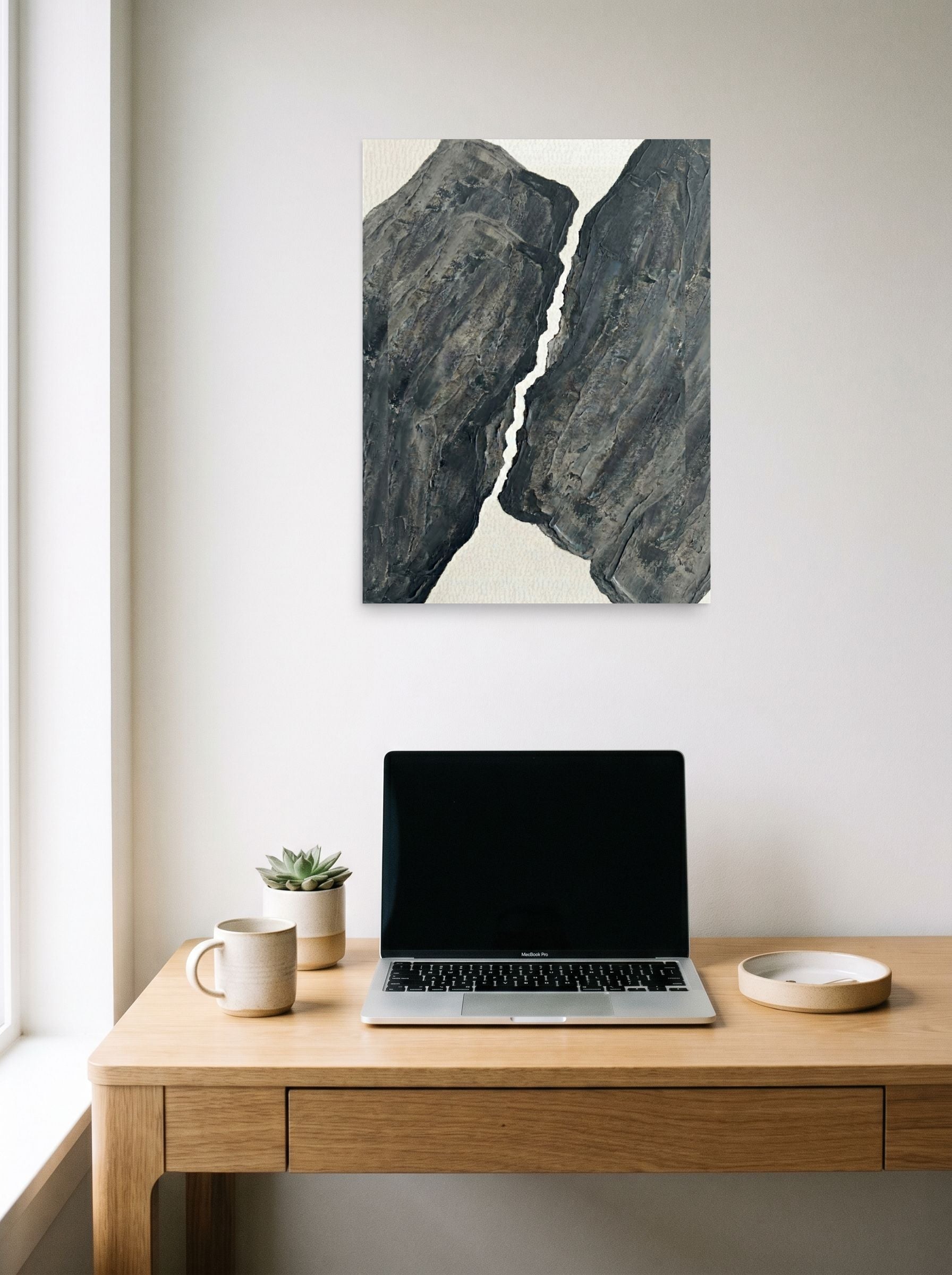 A 18x24 inch unframed paper Abstract art,Minimalism print of 'Fractured Slate' hanging above a worktable with a laptop.