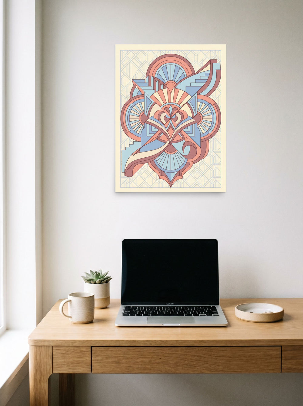 A 18x24 inch unframed paper Art Deco print of 'Deco Architect's Emblem' hanging above a worktable with a laptop.