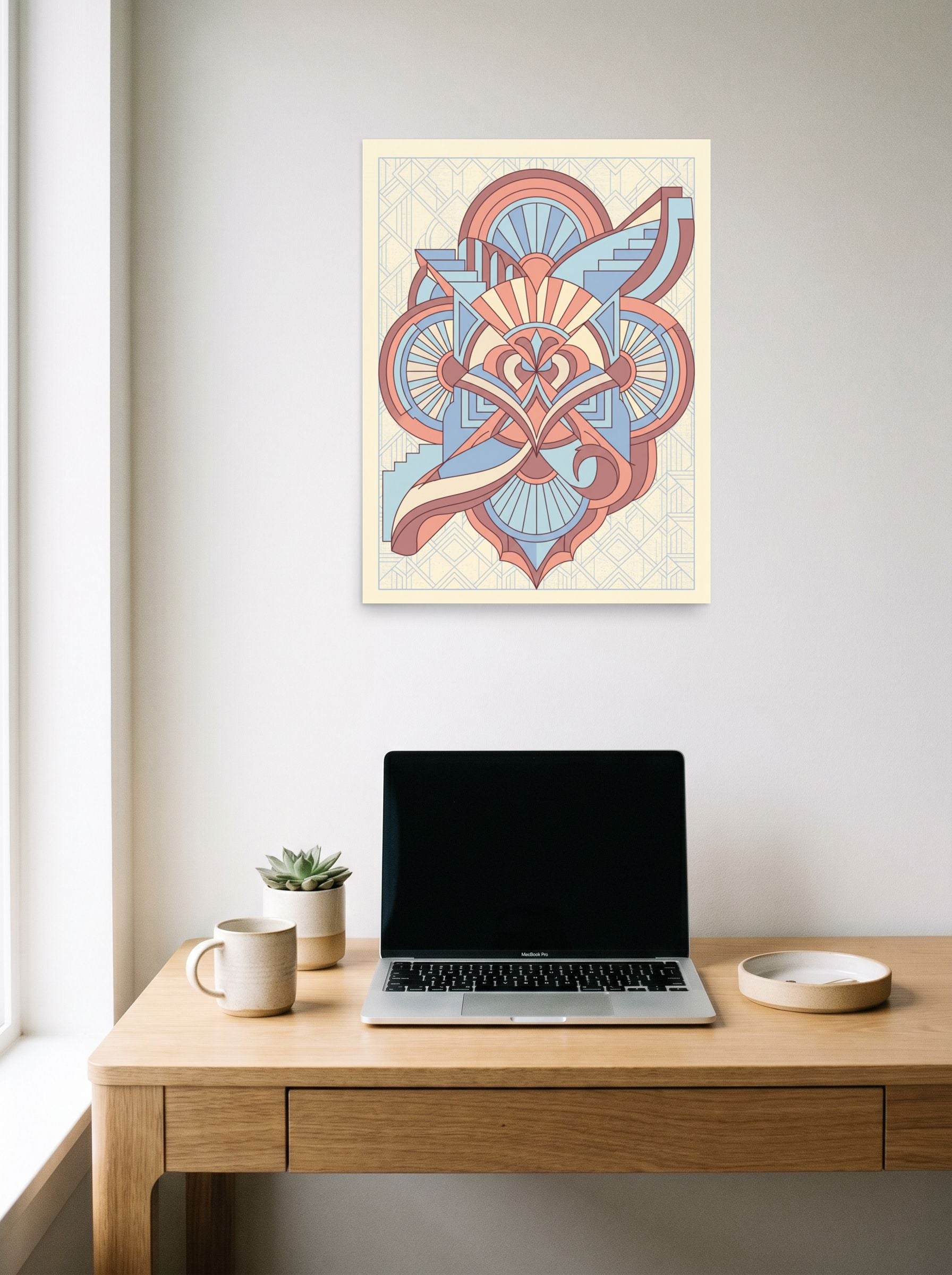 A 18x24 inch unframed paper Art Deco print of 'Deco Architect's Emblem' hanging above a worktable with a laptop.