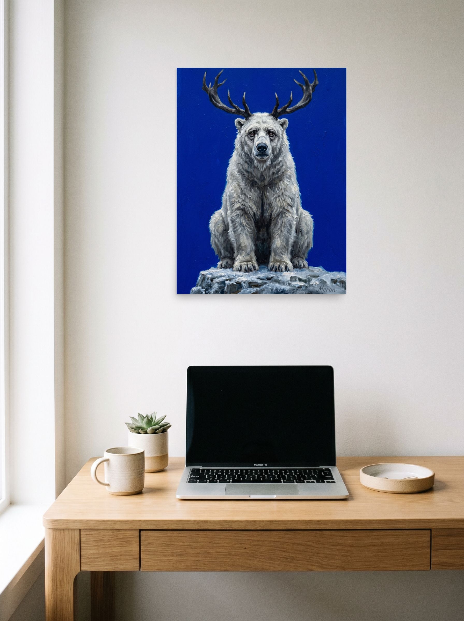 A 18x24 inch unframed paper Surrealism,Expressionism print of 'The Horned Bear' hanging above a worktable with a laptop.