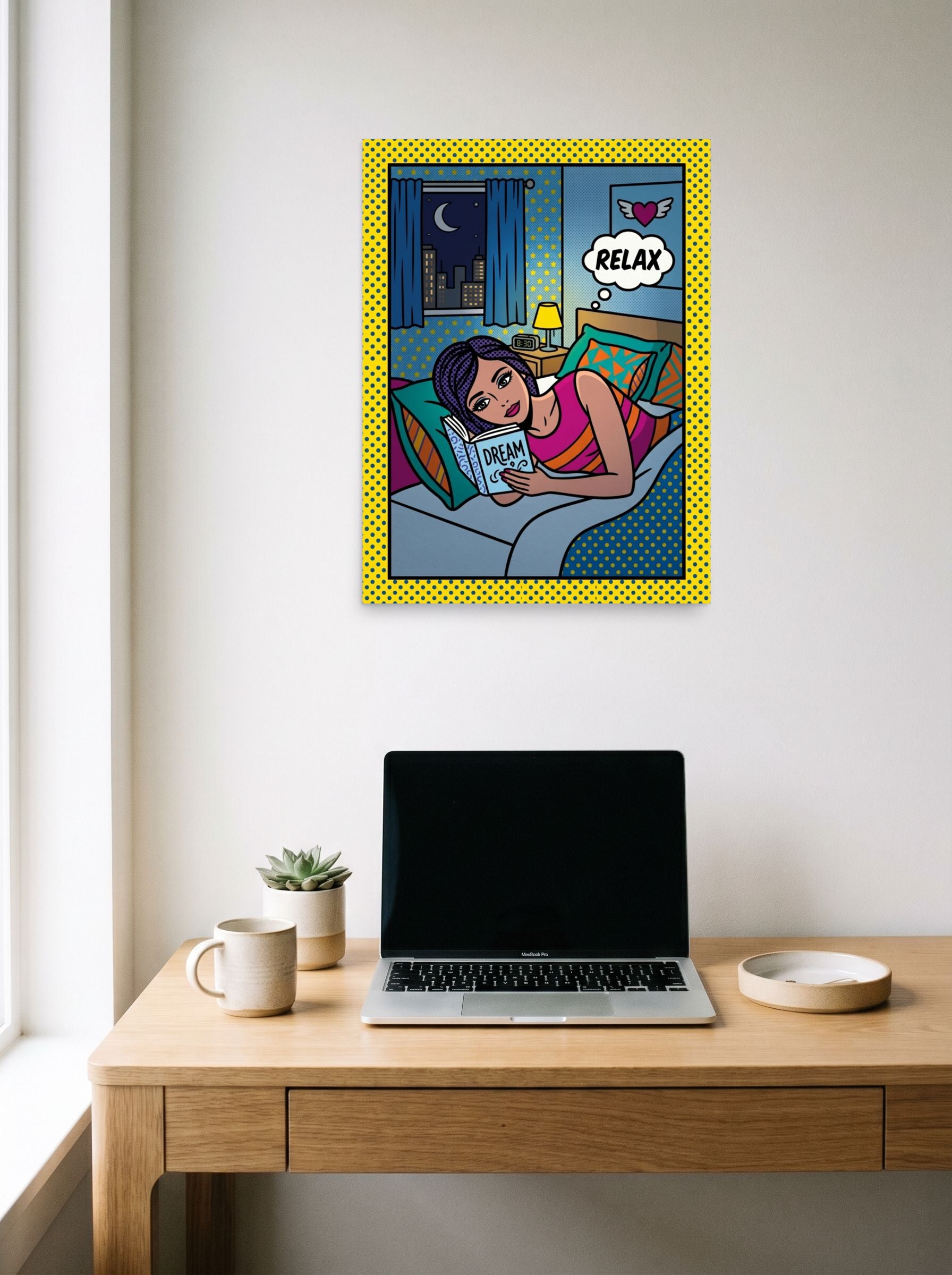 A 18x24 inch unframed paper Pop art print of 'Relax and Dream' hanging above a worktable with a laptop.