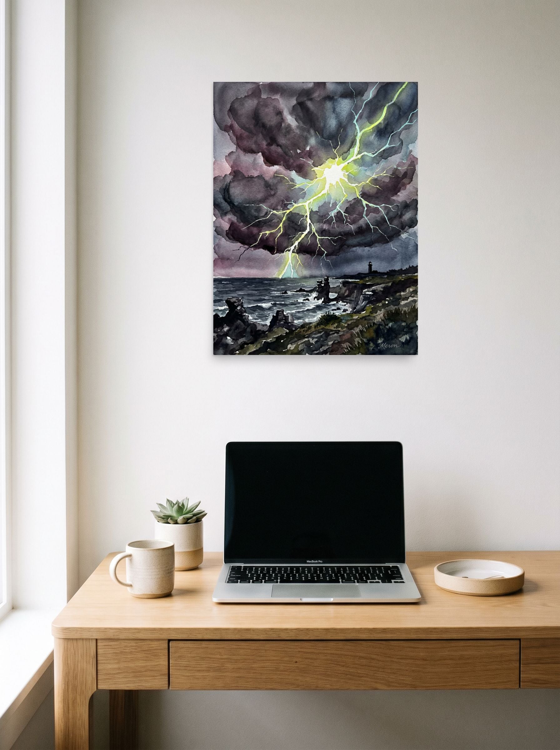 A 18x24 inch unframed paper Expressionism print of 'Coastal Thunderstorm II' hanging above a worktable with a laptop.